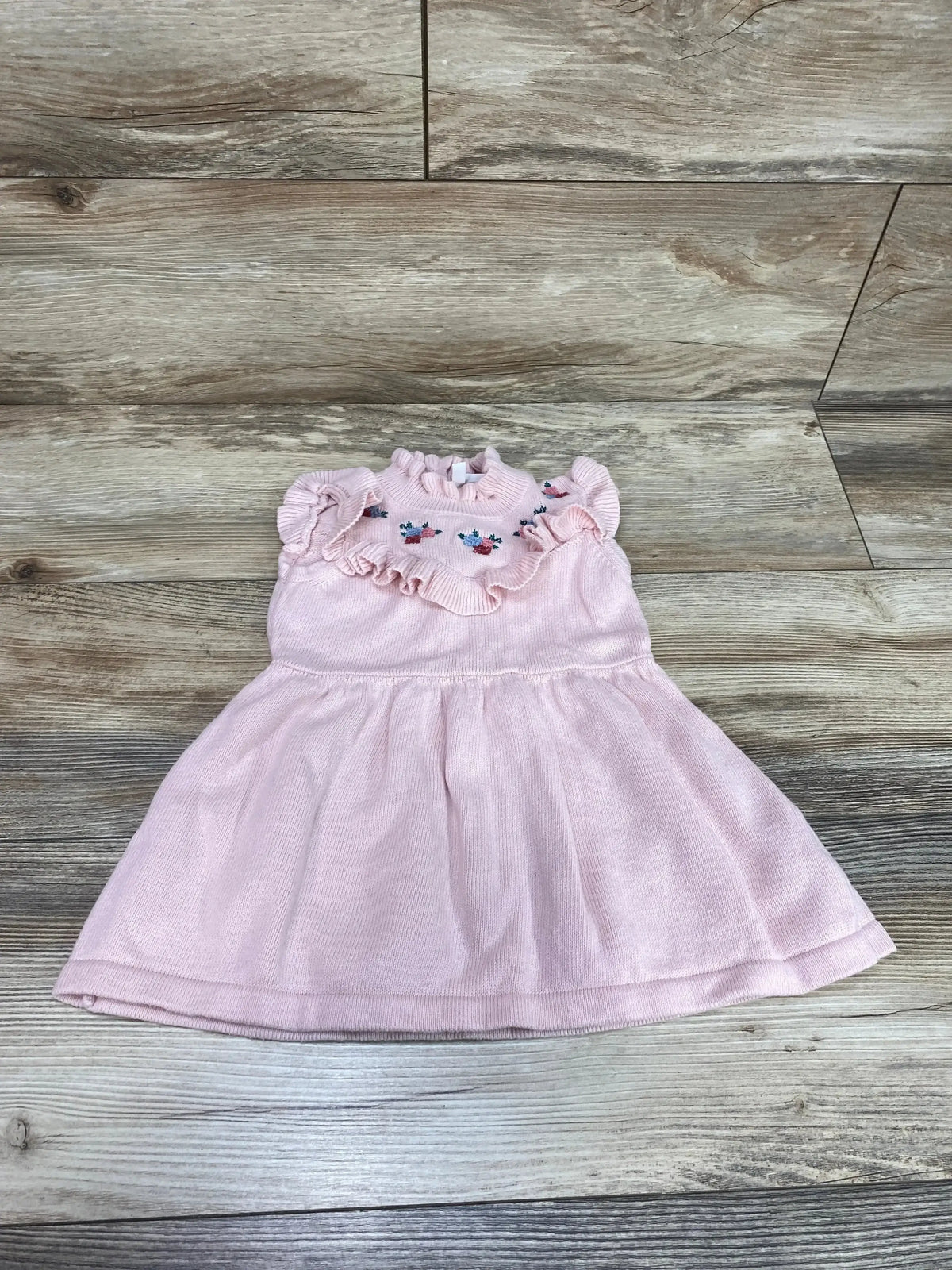 Front view of Janie and Jack Ruffle Embroidered Dress size 12-18m showcasing soft pink fabric with floral embroidered yoke and flutter sleeves on wood plank floor