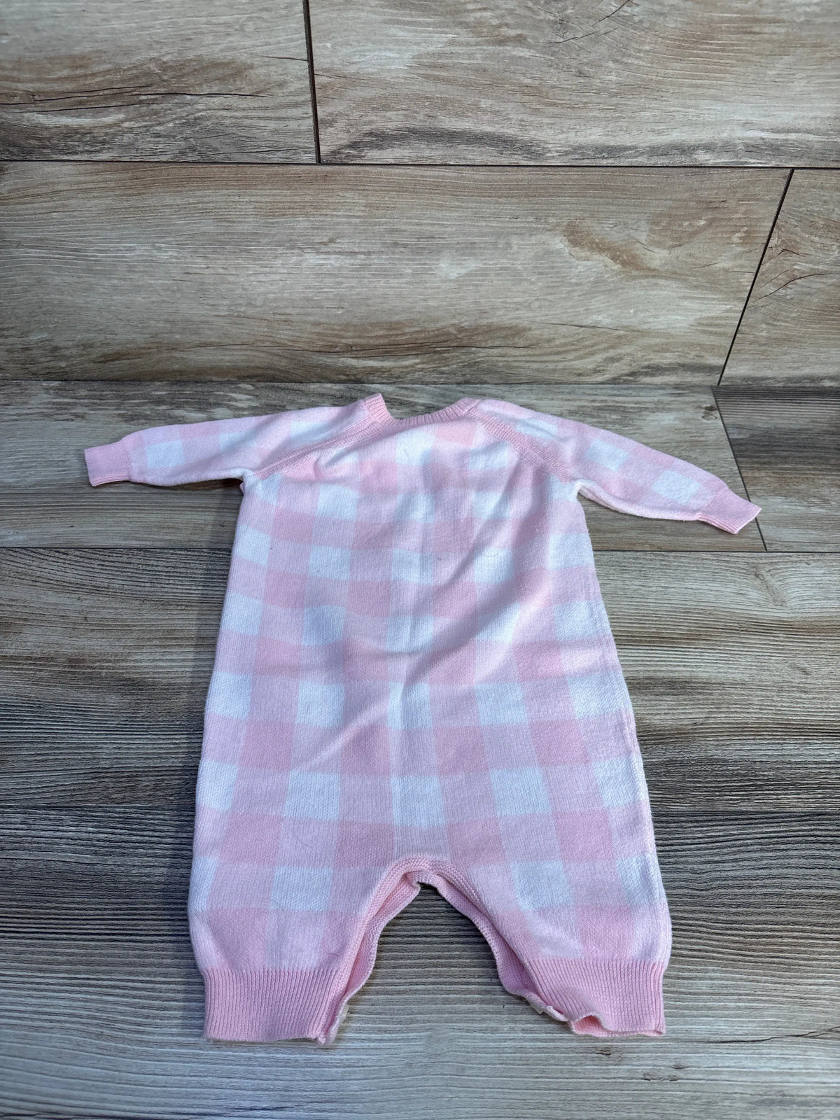 Front view of Ralph Lauren gingham cotton sweater coverall showcasing pink and white check pattern, raglan sleeves, and rib-knit cuffs on a wood floor