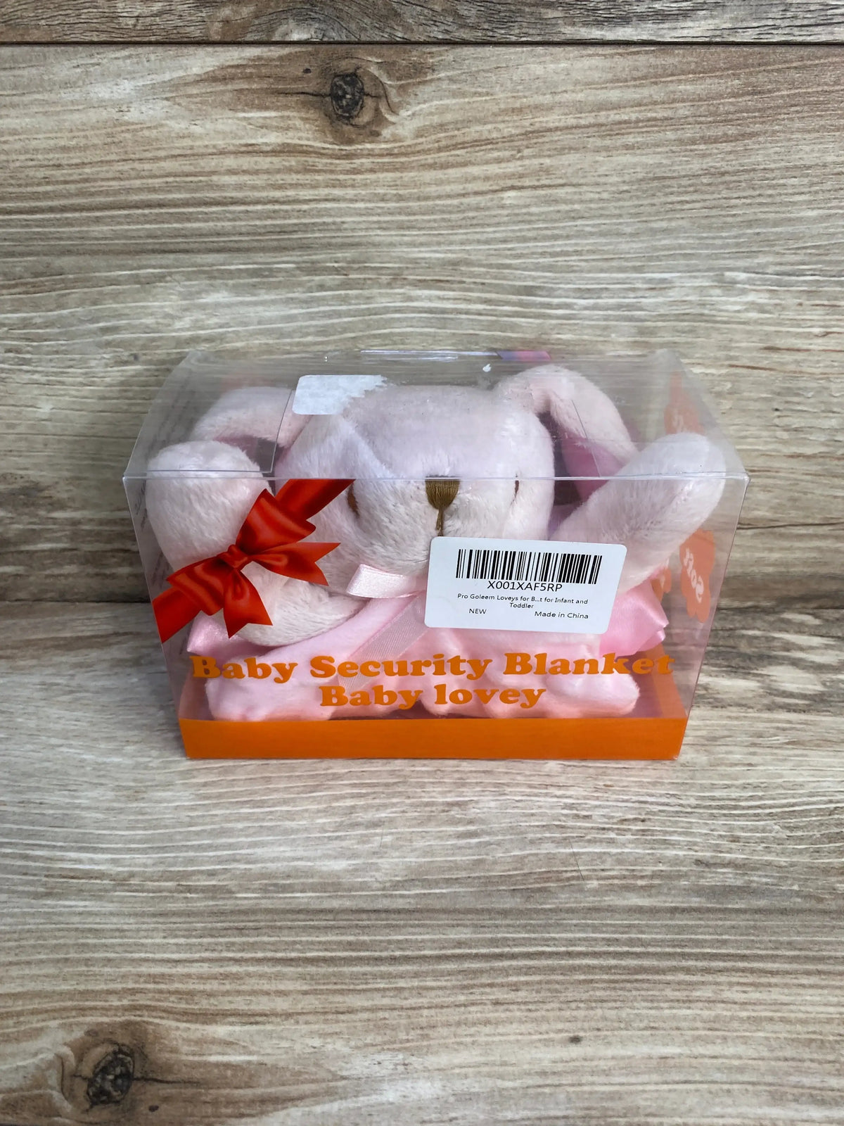 Front view of pink bunny lovey in clear box showing plush bunny head, satin bow and orange text Baby Security Blanket