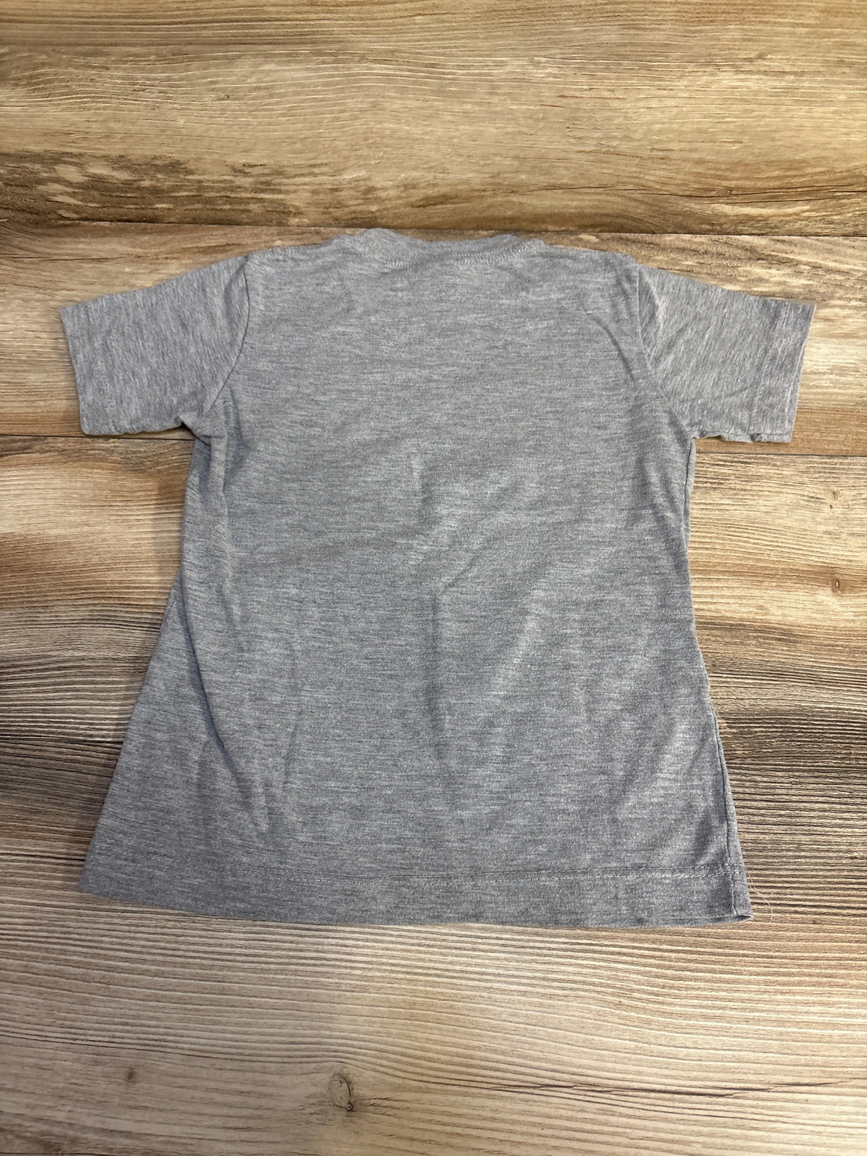 Back view of grey toddler (4T) short-sleeve shirt showcasing heathered fabric and straight hem on wooden floor background