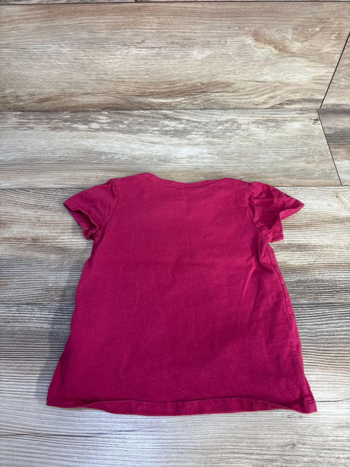 Back view of the Simple Joys by Carters Kind Heart shirt in red, showcasing short sleeves on a wood grain floor