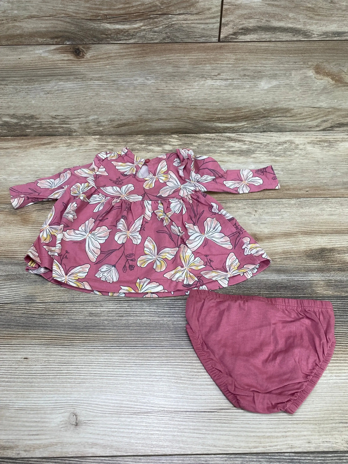 Front view of Carter’s pink butterfly-print baby dress with matching bloomers on white background