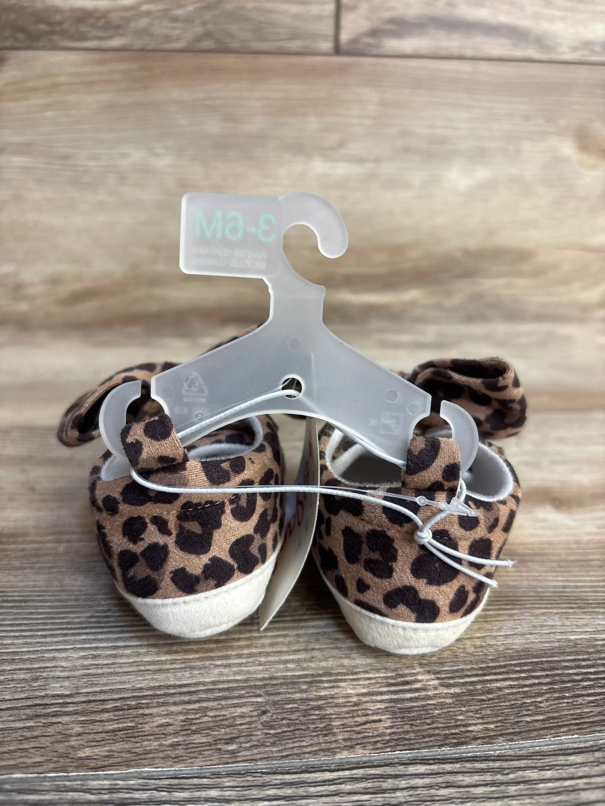 Leopard print baby shoes with white soles, size 3-6M, on hanger