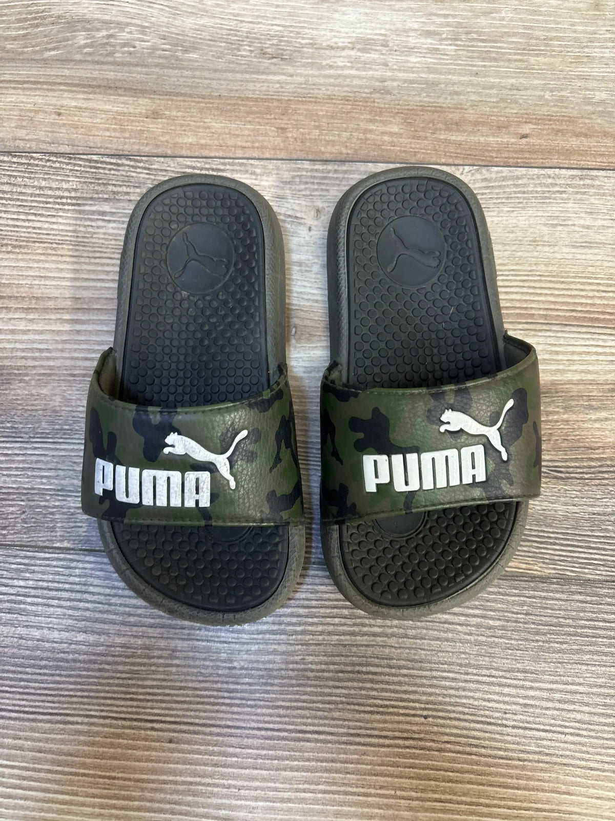 Kids' camo Puma slides with logo on wooden floor