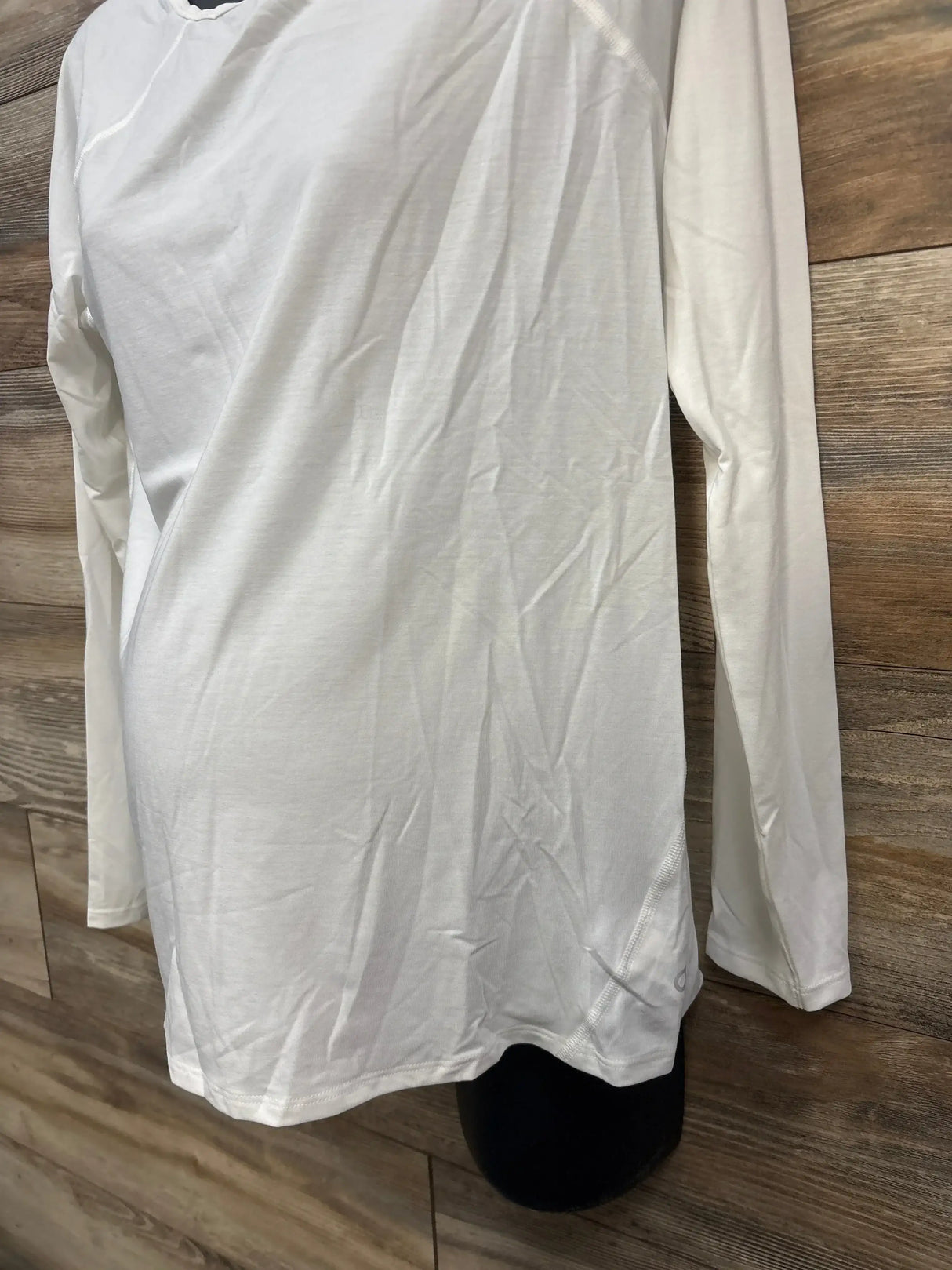 Front view of NWOT Gap Maternity Breathe Long Sleeve Shirt in white size small showcasing crewneck and long sleeves on dress form on wood plank floor