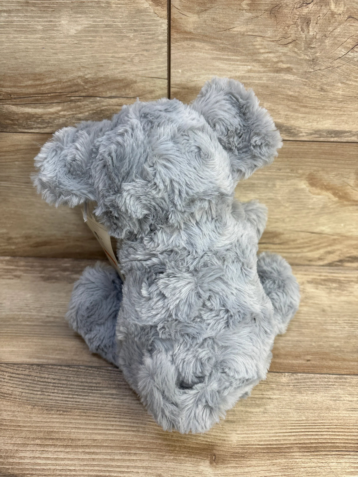 Rear view of Cloud Island grey elephant plush showing soft fuzzy fur and attached mini elephant on wood plank background