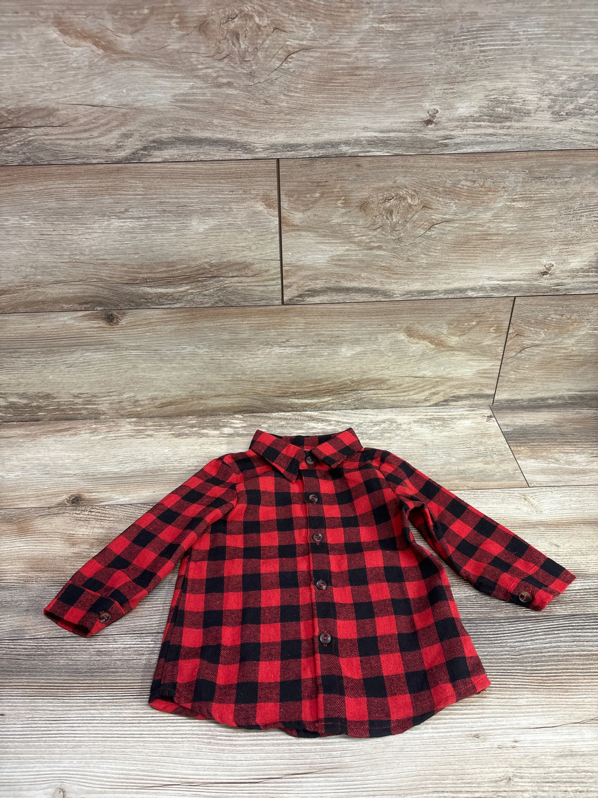 Front view of Mersariphy flannel shirt showcasing red and black plaid, button front, and long sleeves with wood-look background