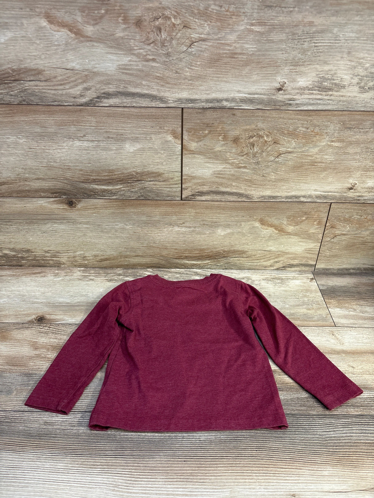 Back view of Kids Headquarters red long-sleeve toddler shirt (3T) showing plain back and crew neckline on wood plank background