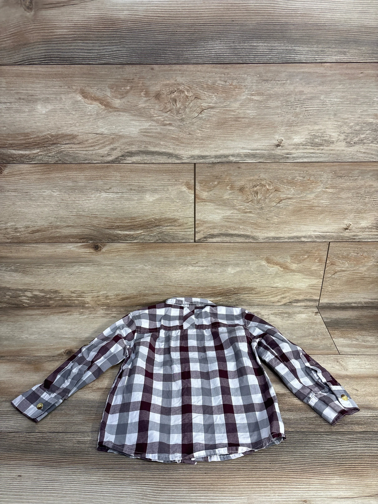 Back view of a long-sleeve checkered shirt in white, gray, and burgundy on wooden floor