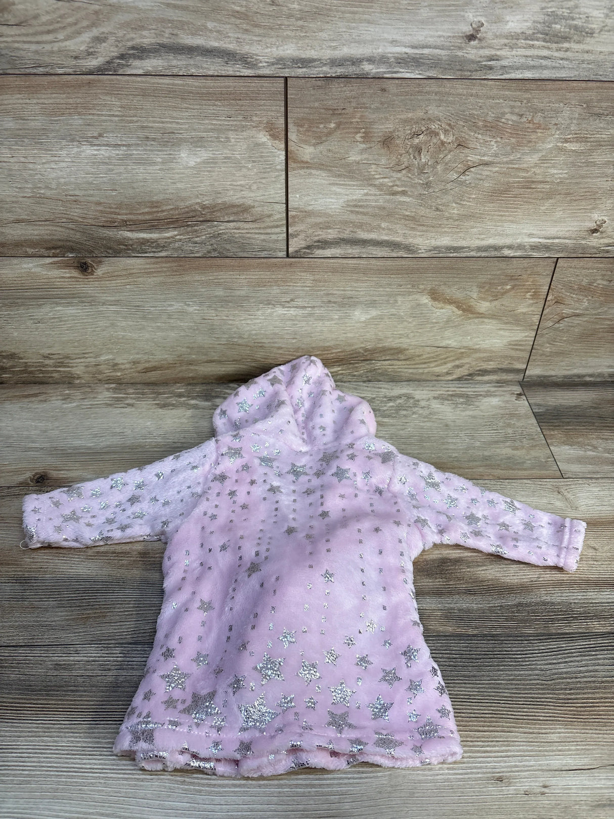 Pink toddler hooded fleece jacket with silver star pattern on wooden background