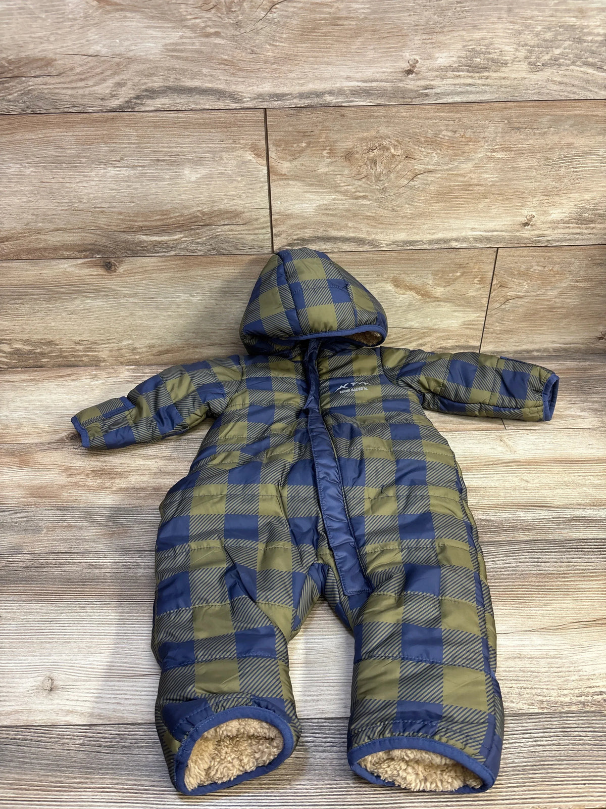 Green and blue plaid Me n Mommy To Be fur lined hooded baby snowsuit on a wood background