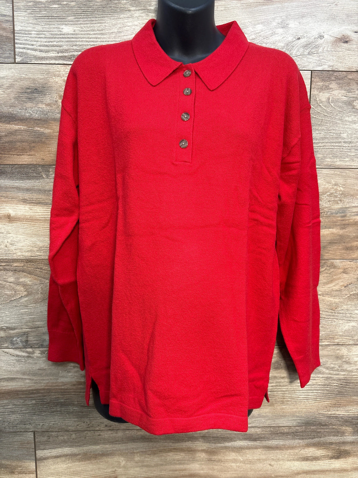 Red long sleeve polo shirt with buttons displayed on mannequin against wood background