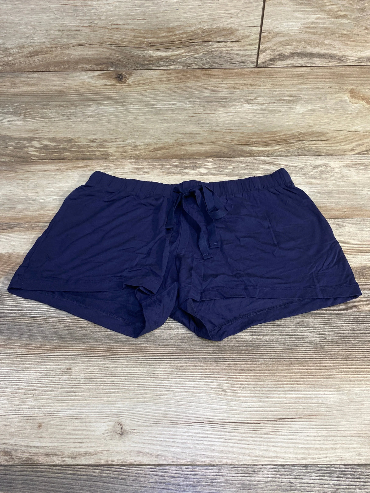 Flat lay of navy Gap Body maternity modal shorts showing elastic drawstring waistband and short inseam on light wood background