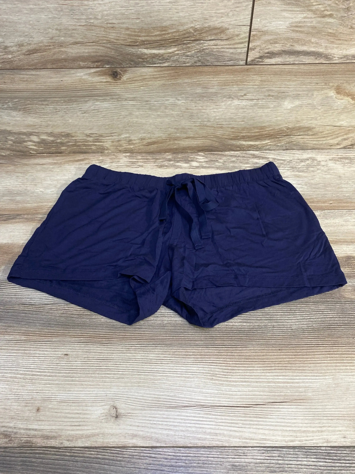 Flat lay of navy Gap Body maternity modal shorts showing elastic drawstring waistband and short inseam on light wood background