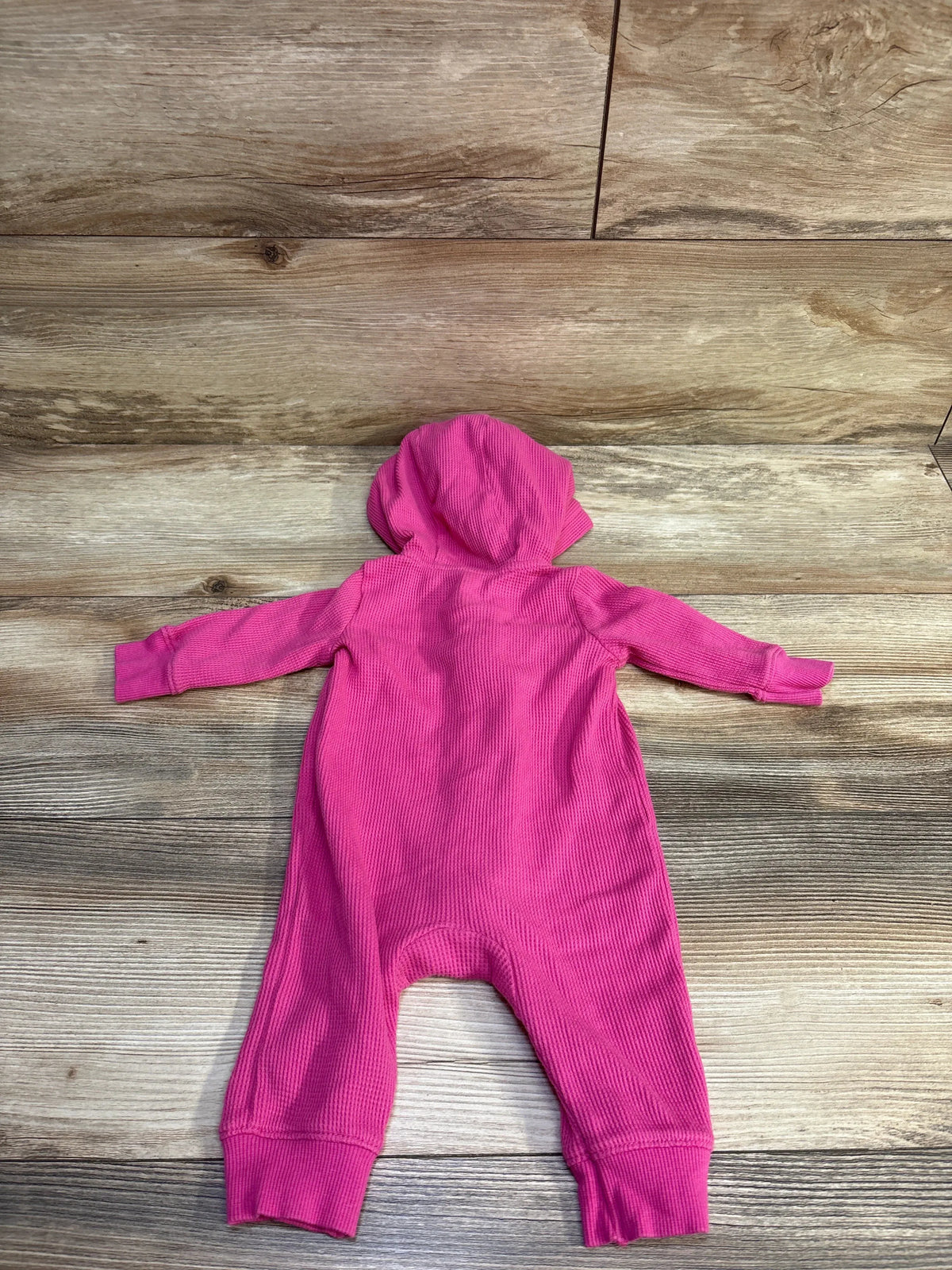 Back view of Carter’s waffle knit hooded coverall, bright pink, showing texture and cuffed legs on wood background, size 3M