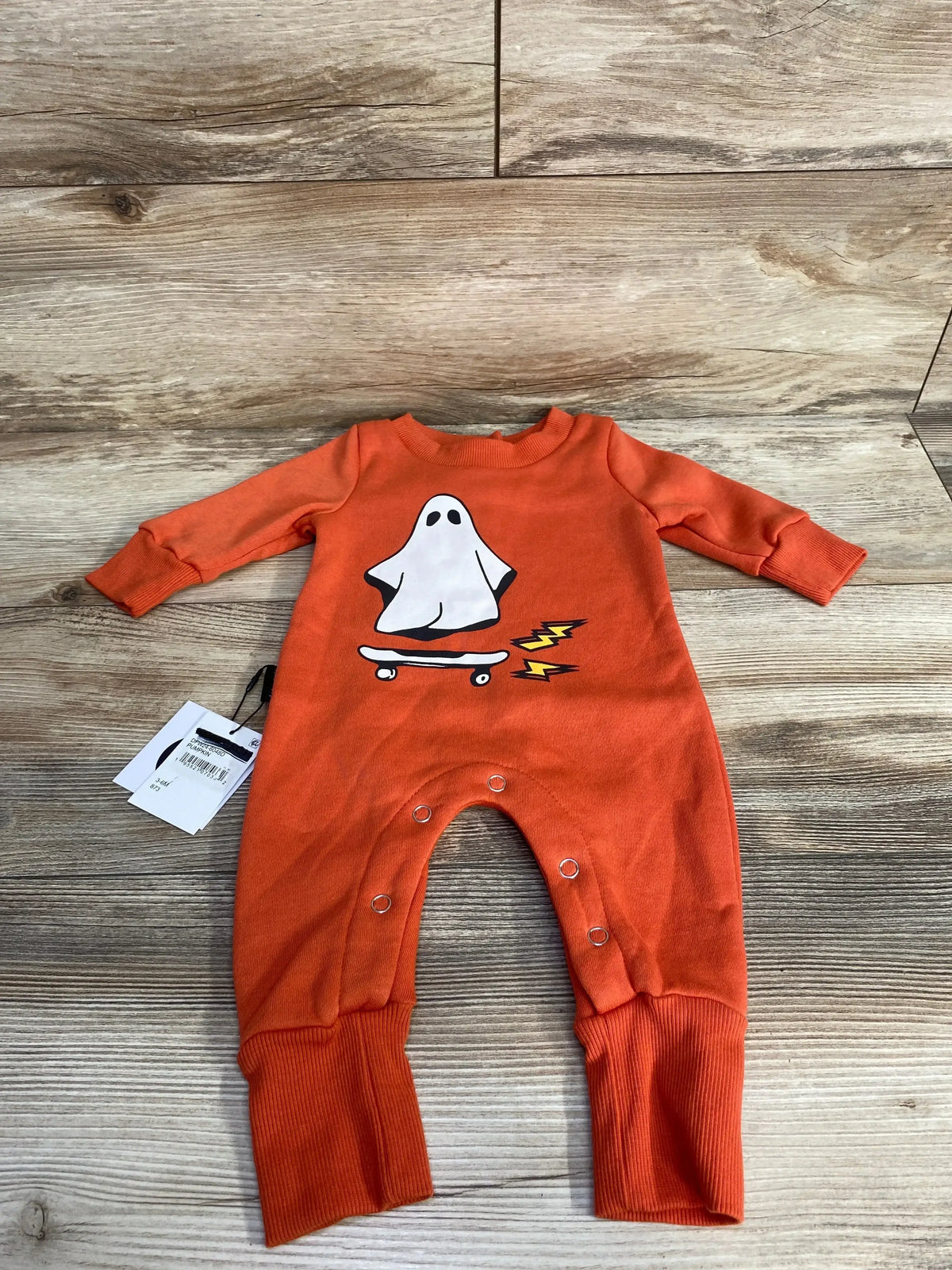 Orange baby onesie with ghost on skateboard, Halloween-themed infant clothing
