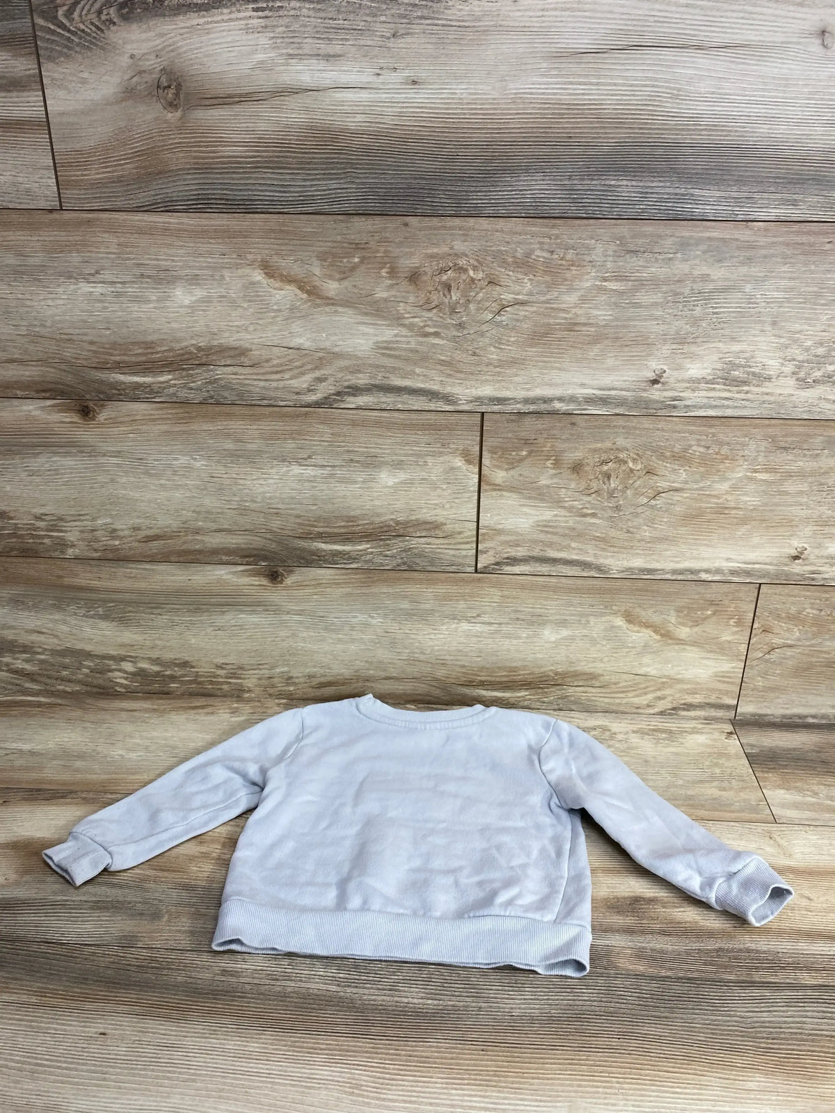 Light gray kids long sleeve sweatshirt on wood floor, cozy children's clothing for resale