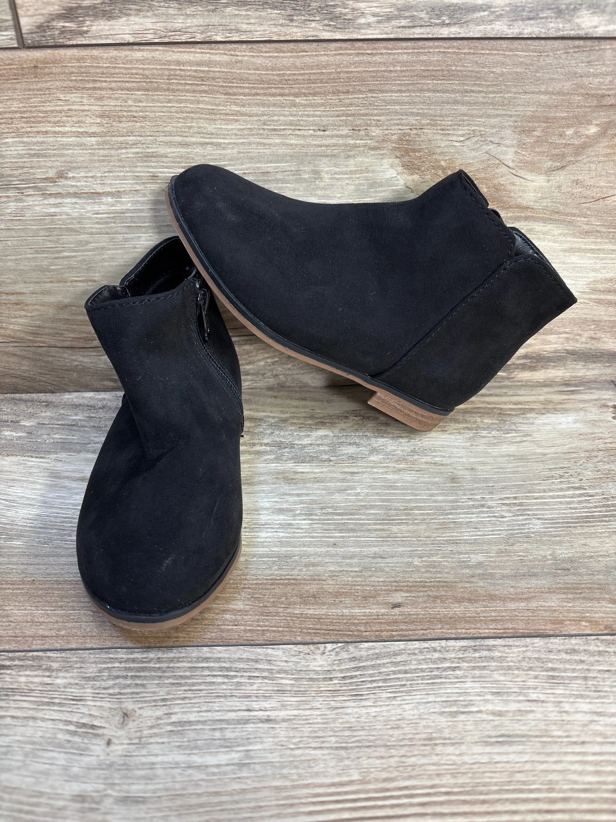 Black suede ankle boots for kids with side zipper on wood floor