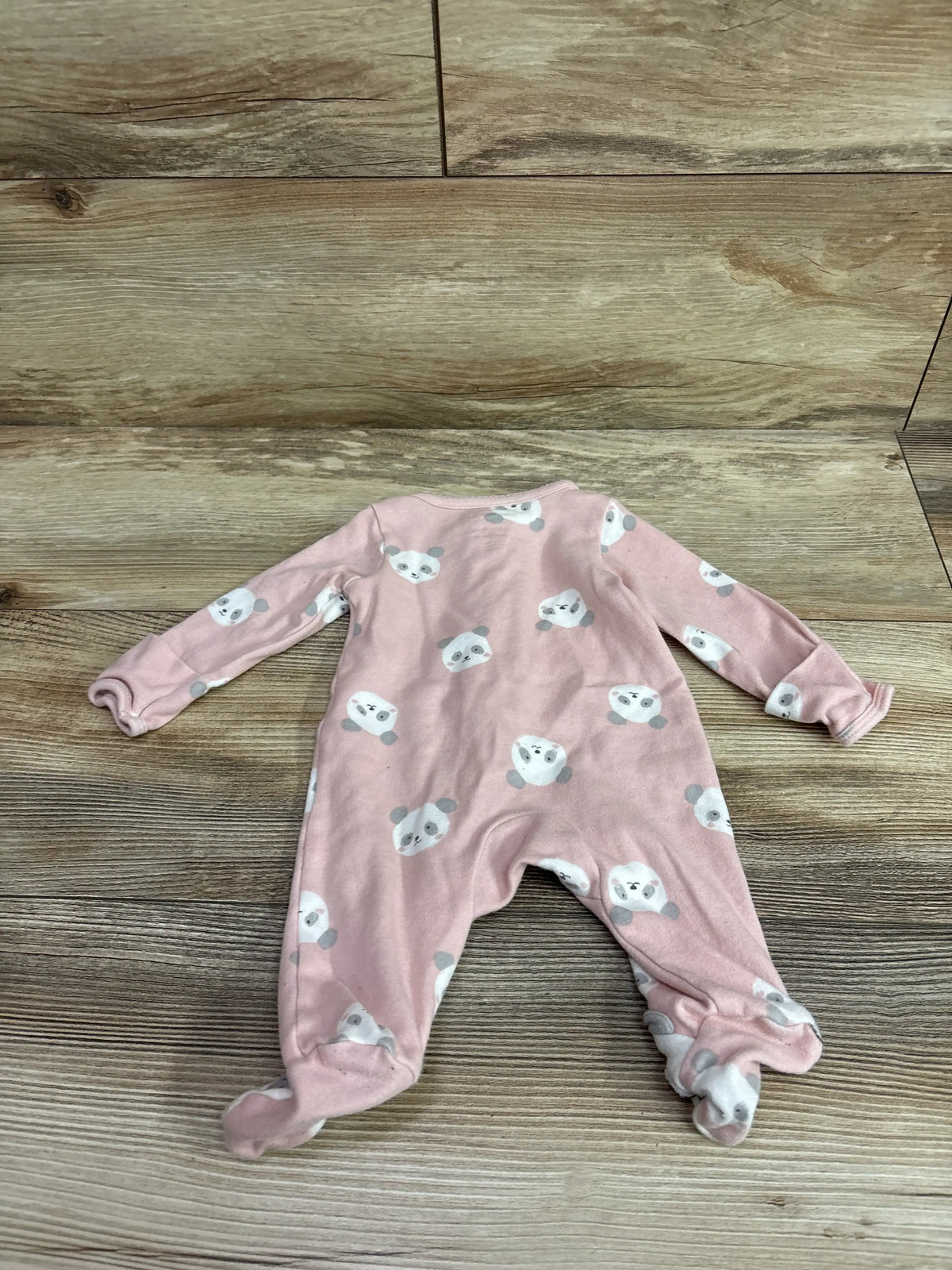 Pink newborn Just One You sleeper with panda print on a wooden background