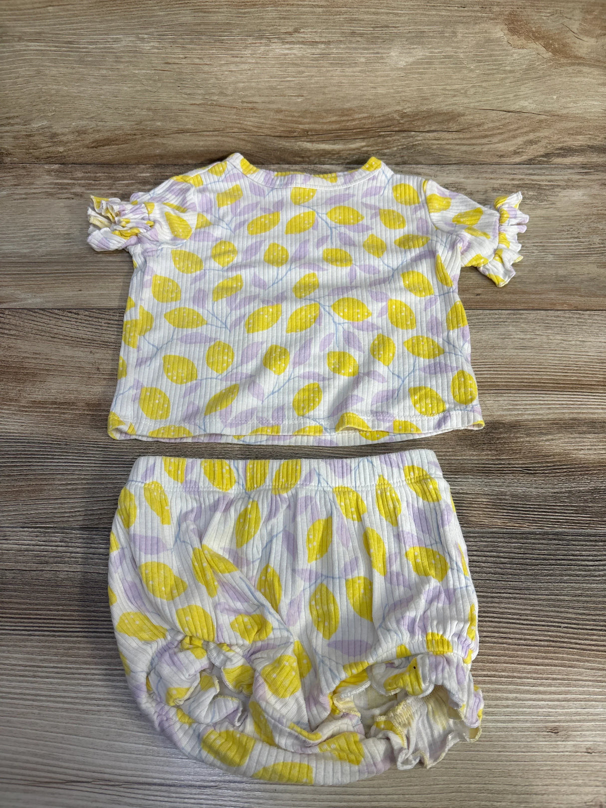 Flat lay of Cat & Jack two-piece lemon-print ribbed top and bloomer with ruffle sleeves and elastic waist on wood floor