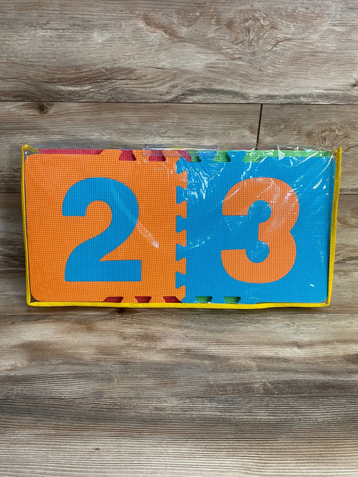 Front view of Lakeshore hopscotch foam mats showing interlocking number tiles 2 and 3 in blue and orange on wood background