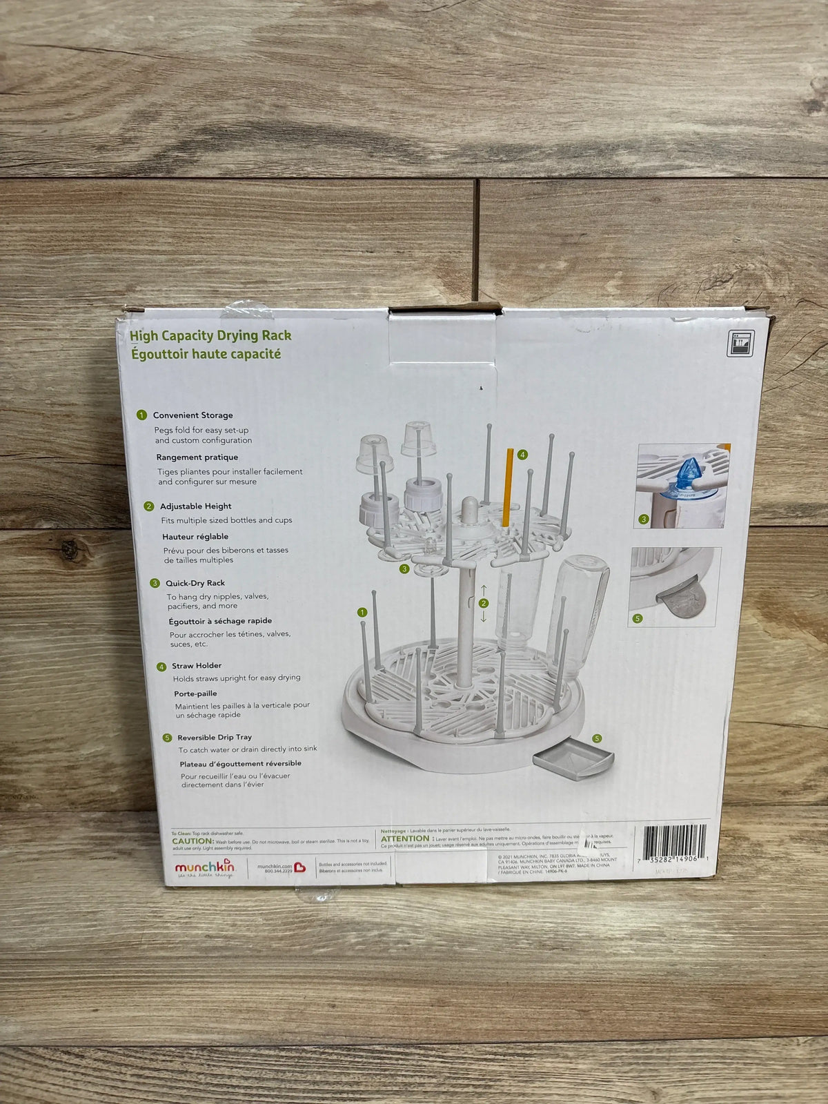 Back of box view of NEW Munchkin High Capacity Bottle Drying Rack showcasing feature illustrations and product details in original packaging on wood plank floor