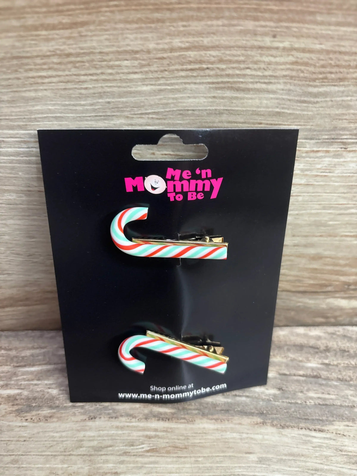 Candy cane hair clips with red, white, and green stripes on black packaging