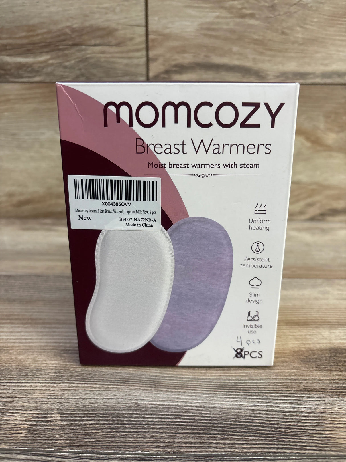 Front view of Momcozy Breast Warmers box showing two pad illustrations, barcode sticker and handwritten 4 pcs