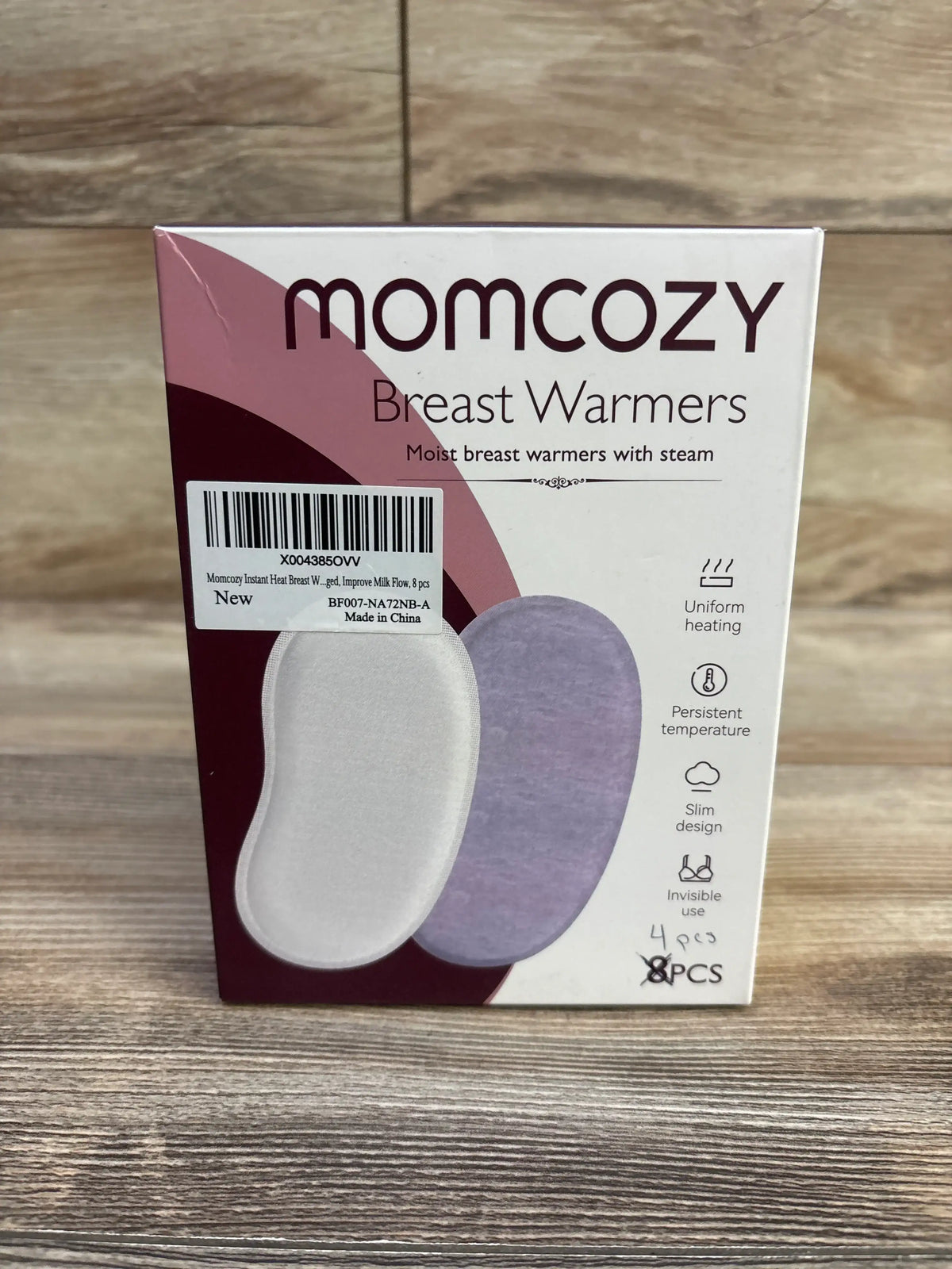 Front view of Momcozy Breast Warmers box showing two pad illustrations, barcode sticker and handwritten 4 pcs