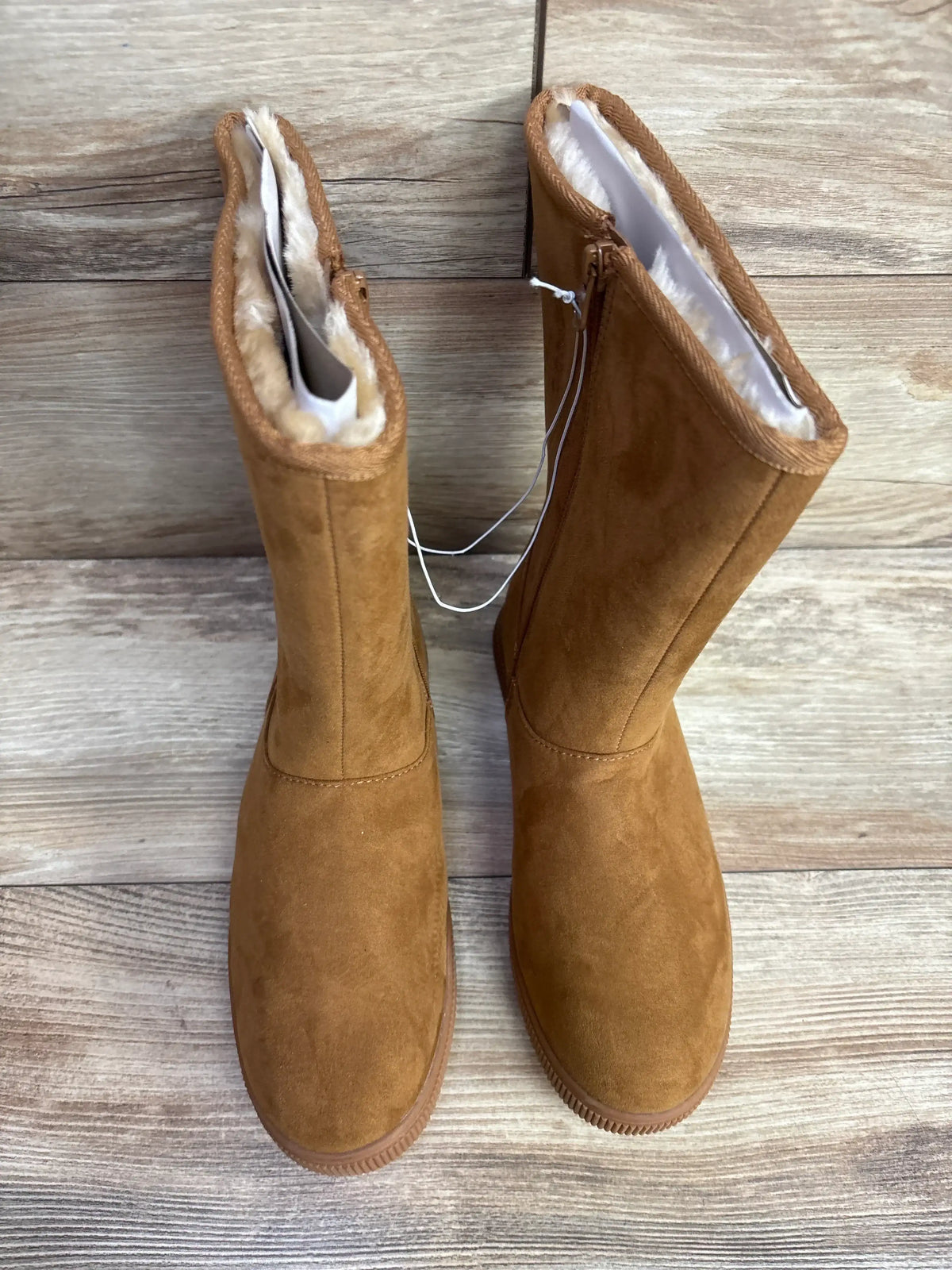 Top-down view of Cat and Jack Natalia tall boots size 5Y showing tan suede and cream faux-fur lining on wooden floor