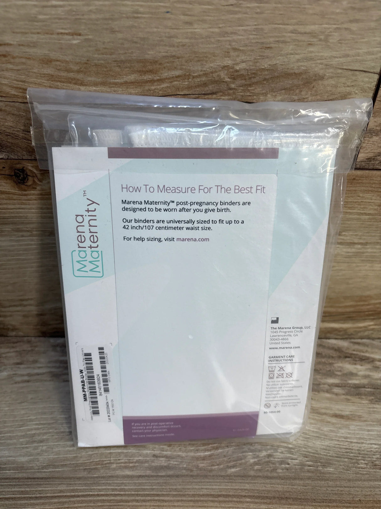 Marena Maternity post-pregnancy binder in packaging on wood background, postpartum support