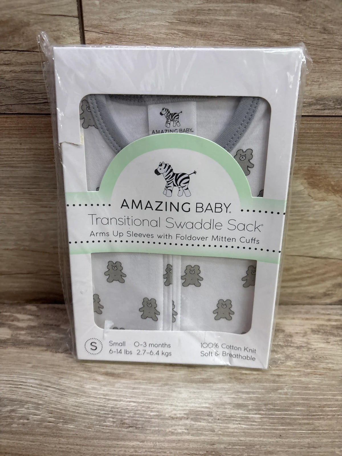 Front view of white Amazing Baby transitional swaddle sack with teddy bear print, arms-up sleeves and mitten cuffs in retail packaging