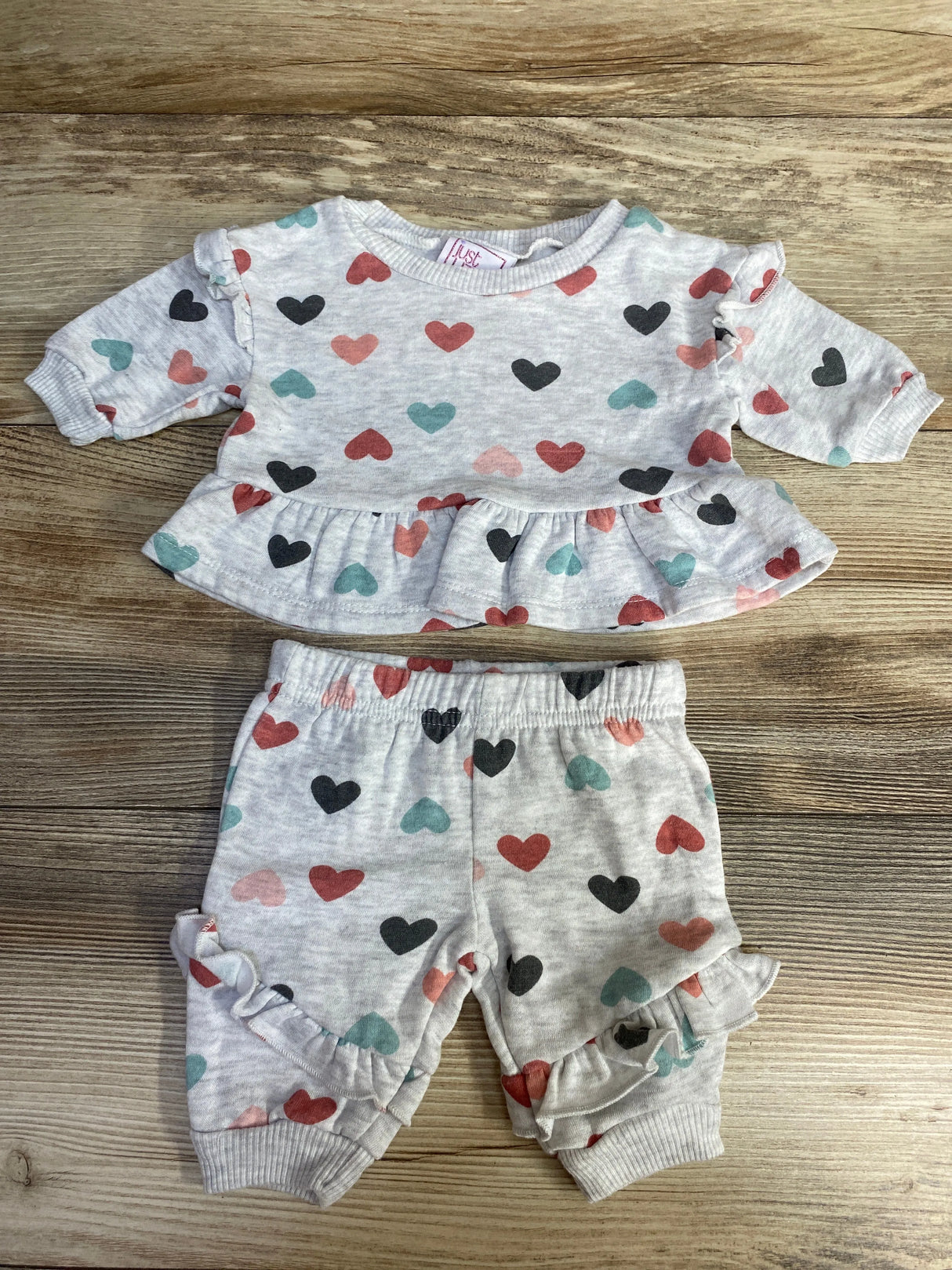 Baby girl heart print ruffle outfit set on wood background