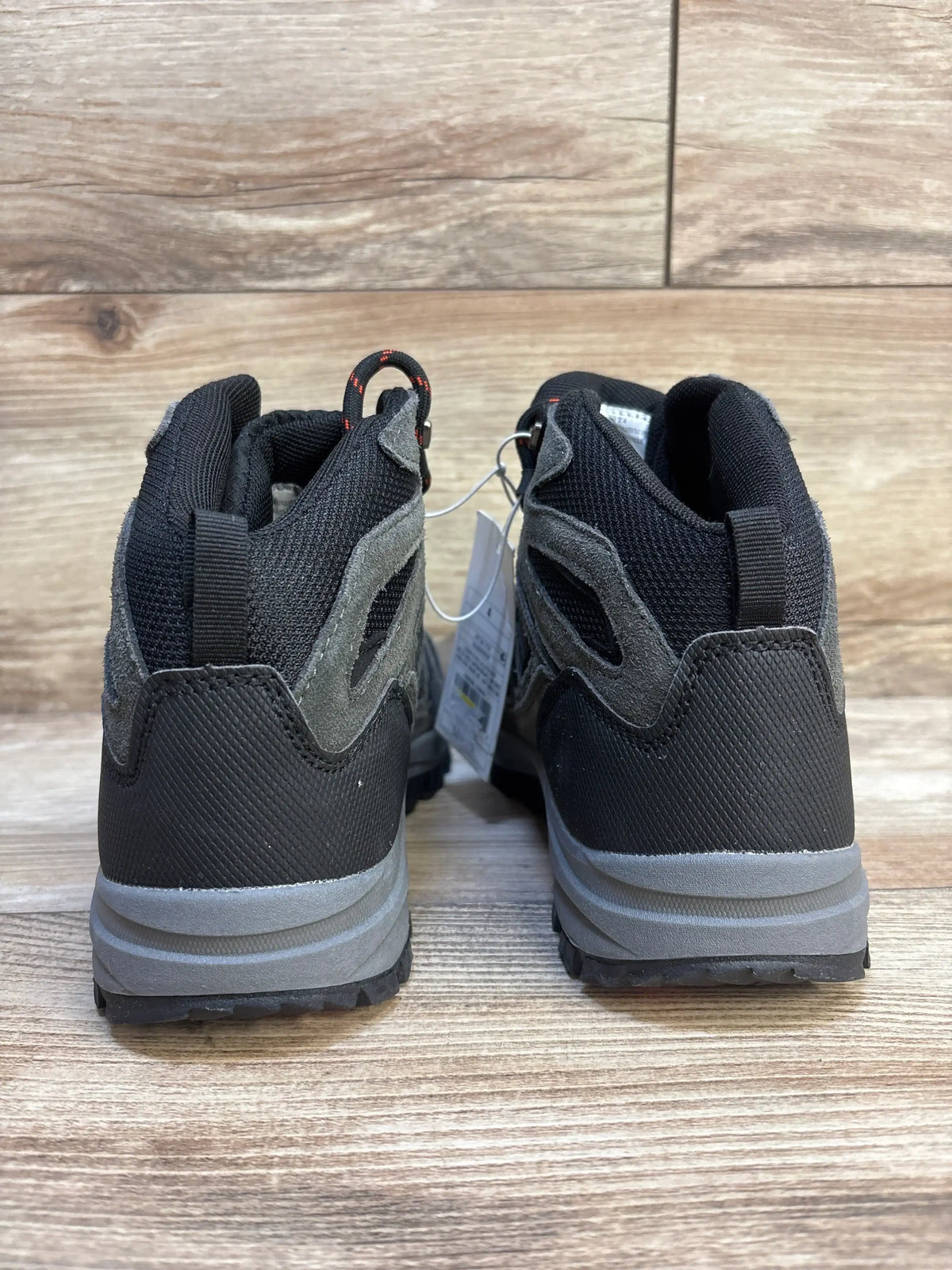 Rear view of Cat & Jack Patsy kids’ hiking boots size 4Y showing black and gray upper, pull tabs and lugged soles on wood floor