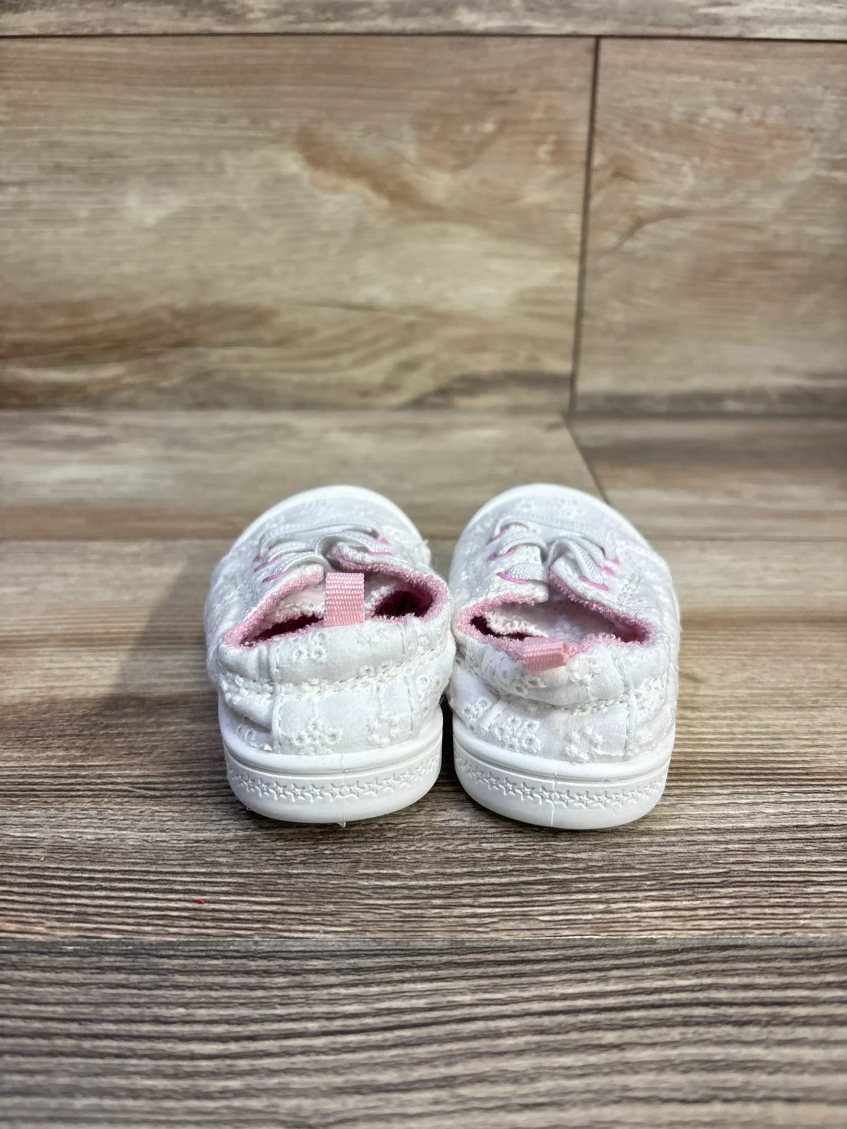 Back view of Wonder Nation baby white eyelet sneakers size 4C showing eyelet fabric and pink lining on wood floor