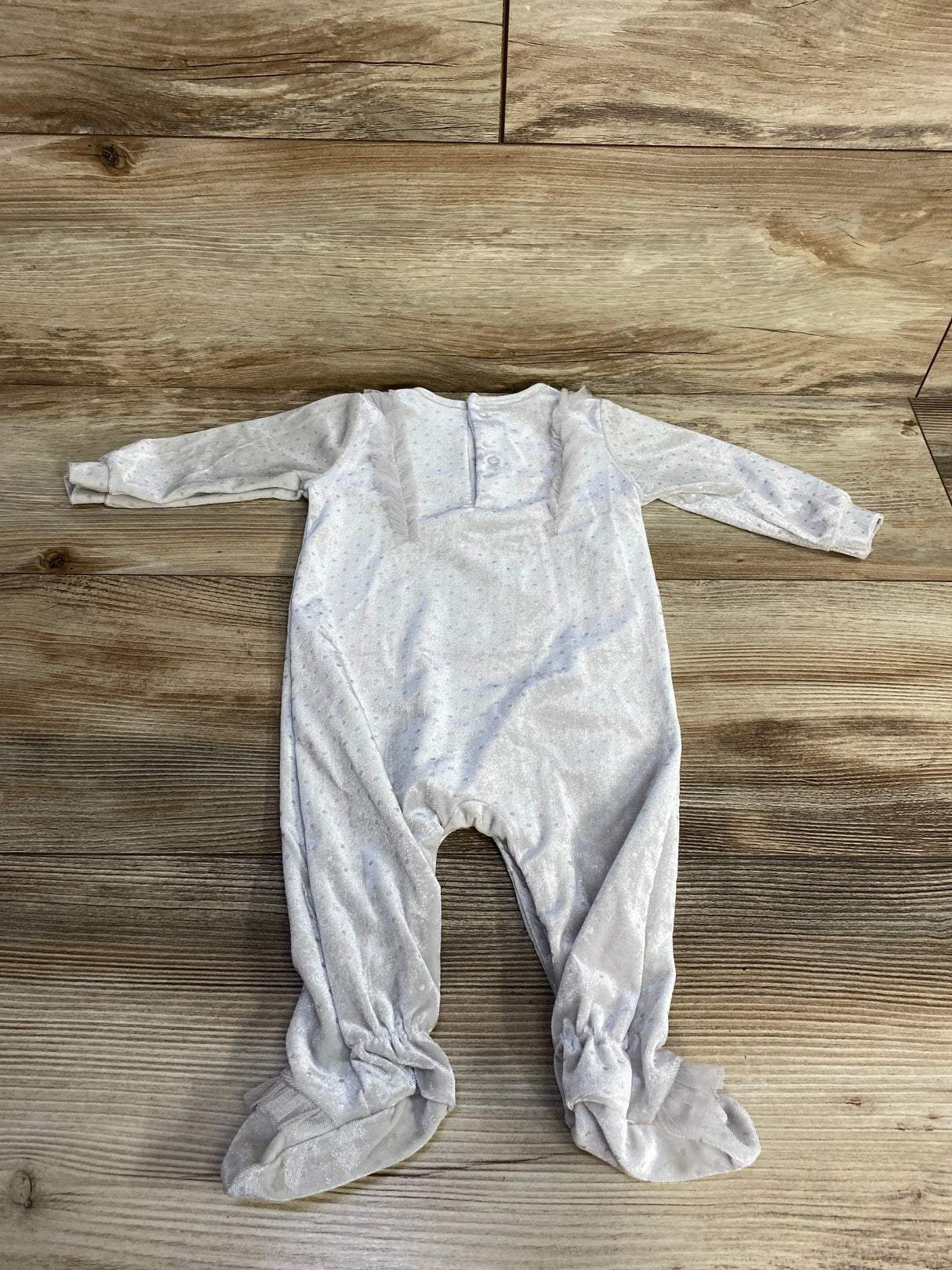 Flat lay of grey velvet baby coverall, 3M, with long sleeves, built-in feet, chest snaps on wood background