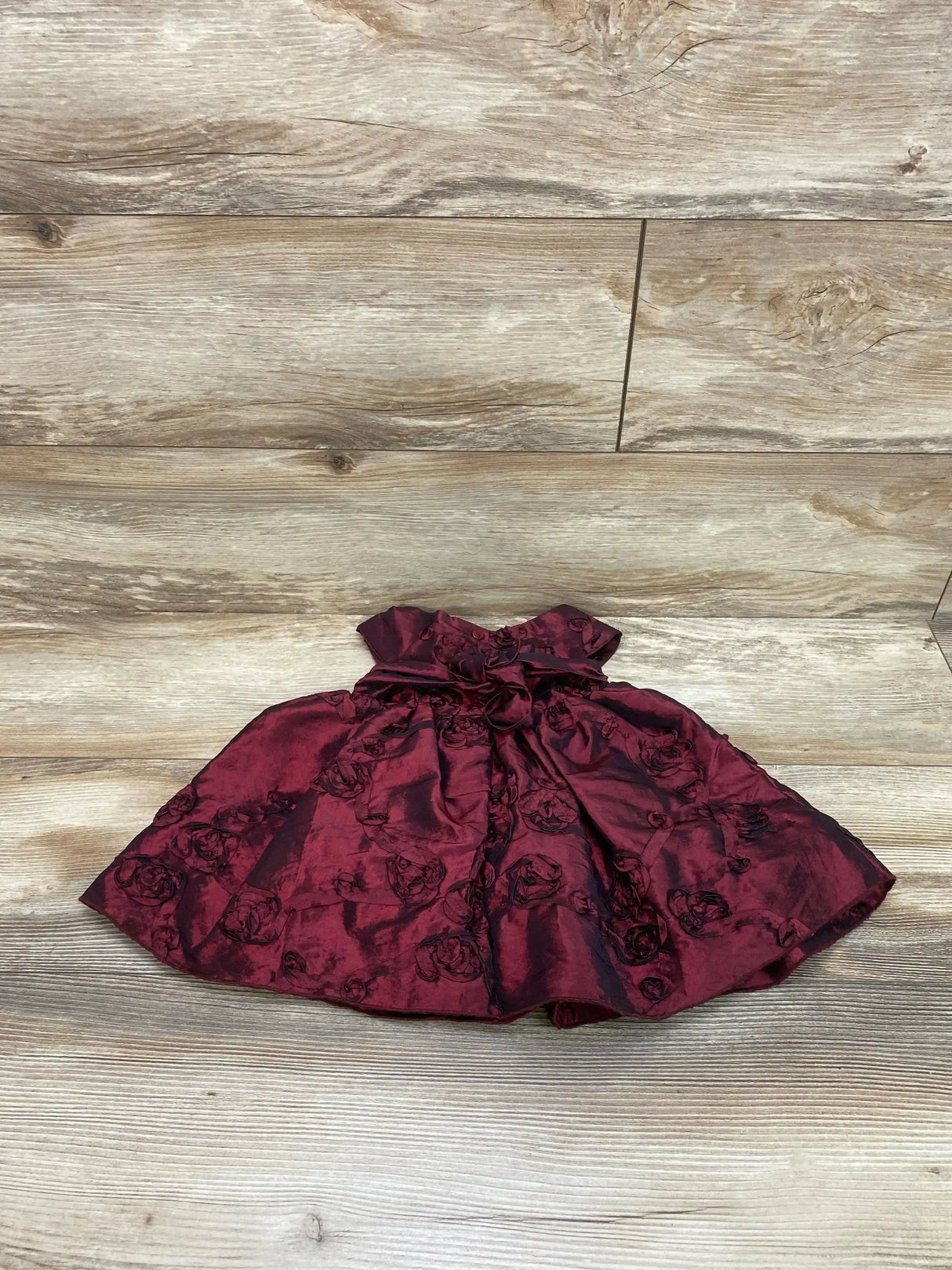 Flat lay of Youngland 2pc Cap Sleeve Dress and Bloomers Red sz 12m showcasing burgundy rose jacquard cap sleeve party dress on wood plank floor