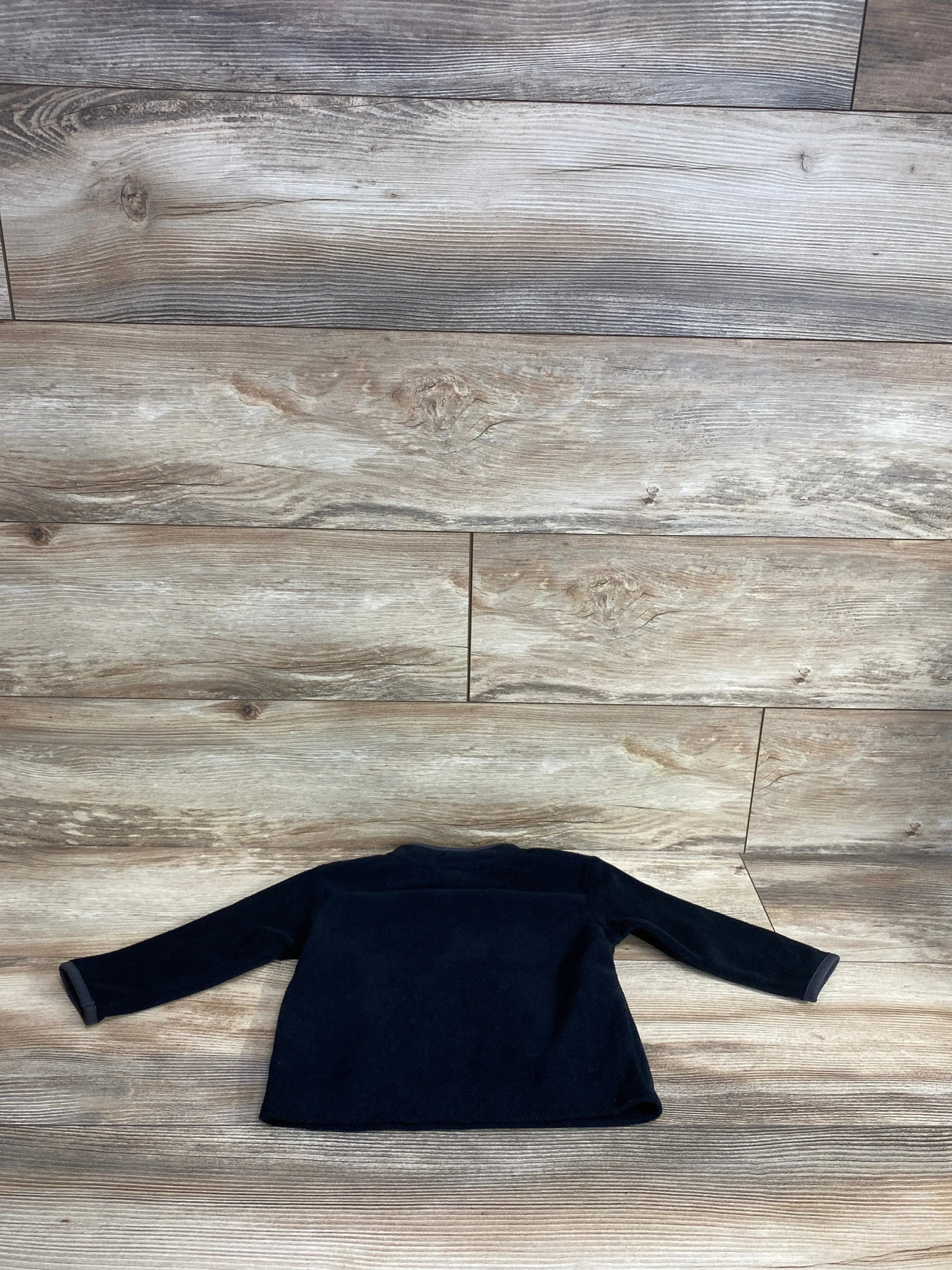 Front view of Cat & Jack 1/4 Zip Fleece Jacket in black showcasing long sleeves on a wooden floor