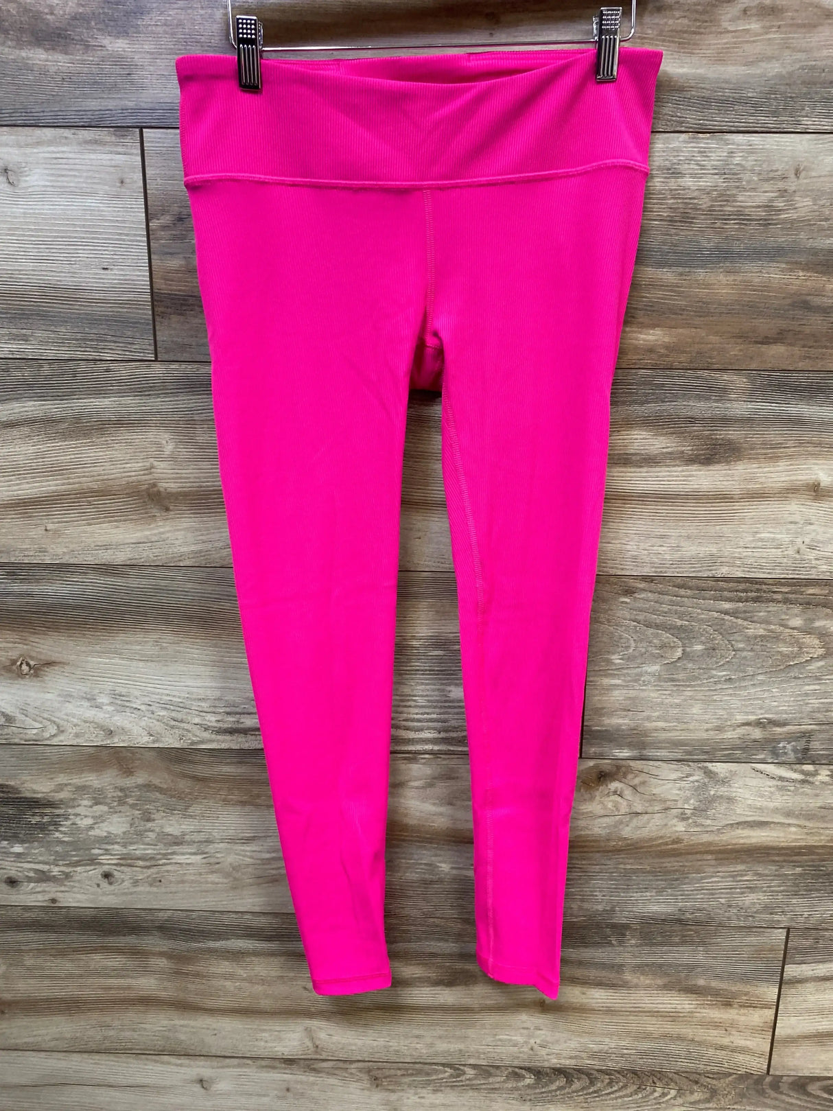 Front view of Gap Fit maternity under-belly leggings in bright pink showing wide ribbed under-belly waistband on wood background