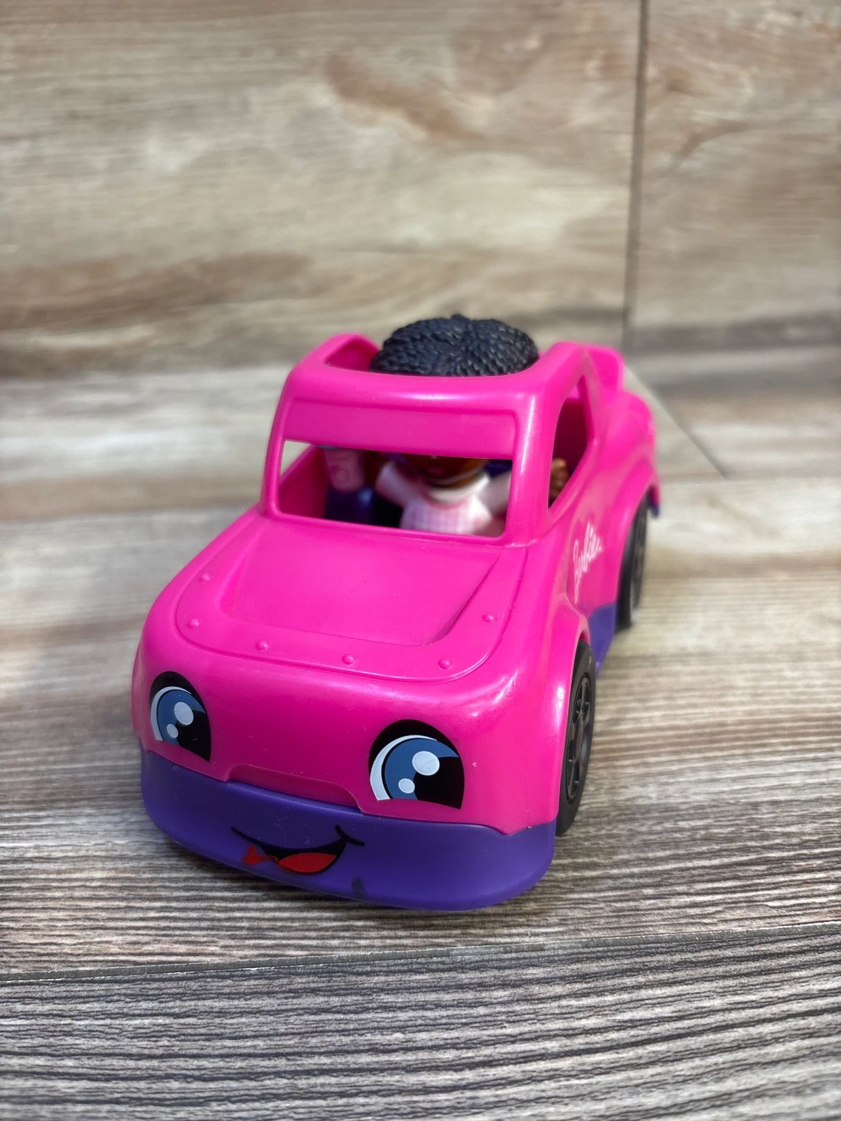 Pink Barbie toy car with doll inside, featuring cute eyes and smile, kids playset