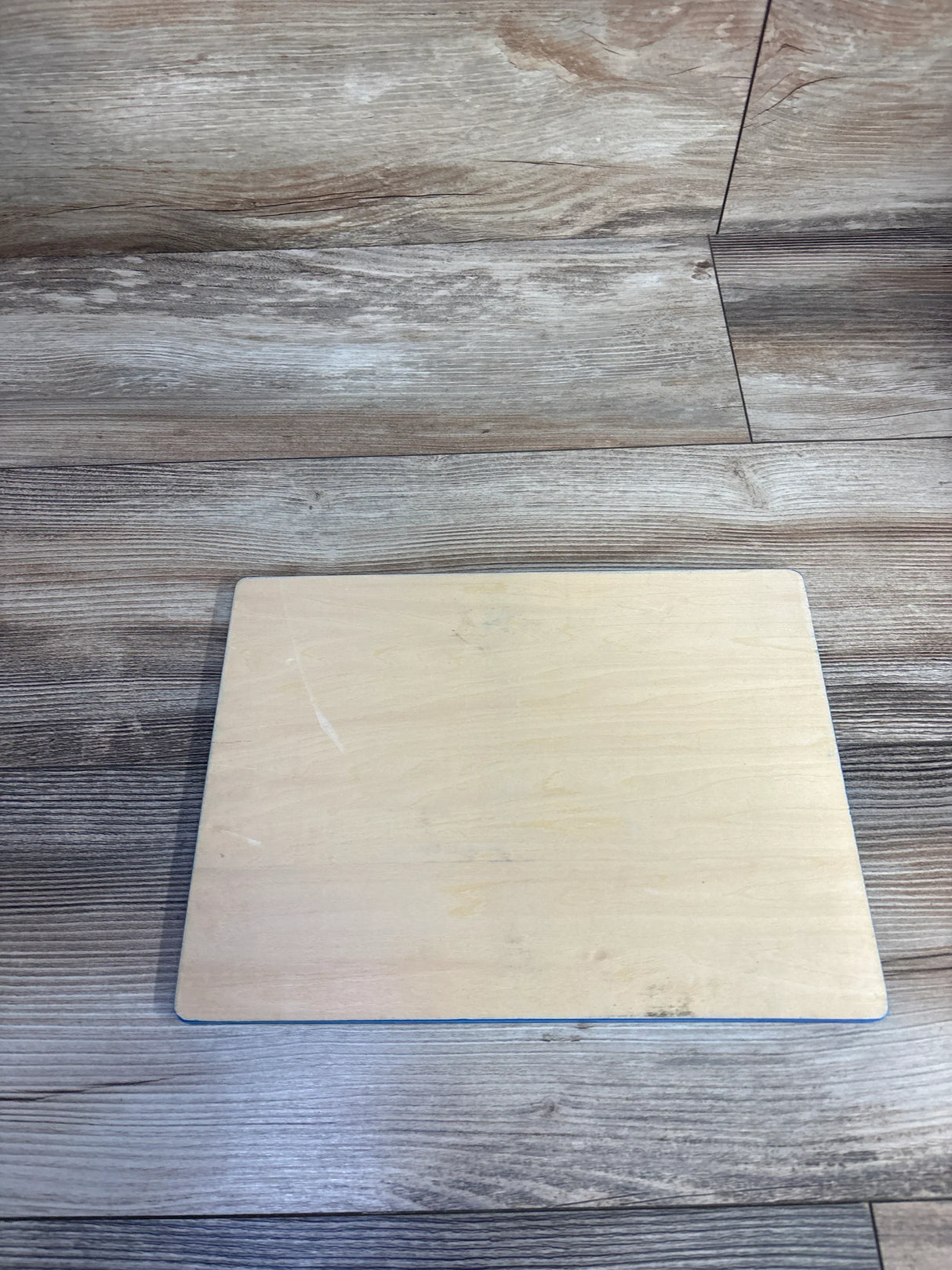 Top view of Lakeshore Wooden Airplane Puzzle 9pc showing plain wooden puzzle board with light scuffs on gray wood floor