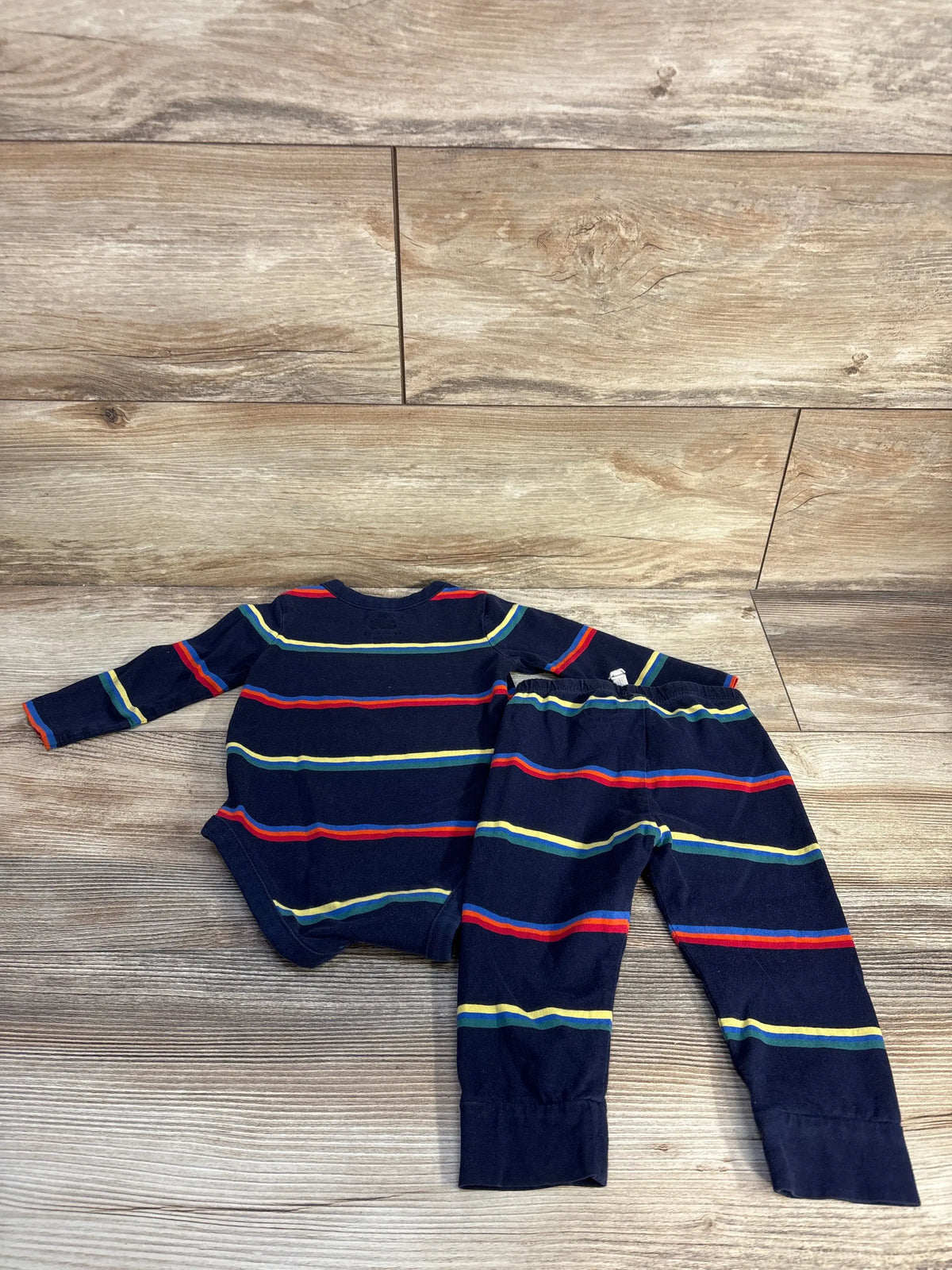 Front view of Baby Gap 2pc striped bodysuit and pants set in navy, laid flat on a wood floor