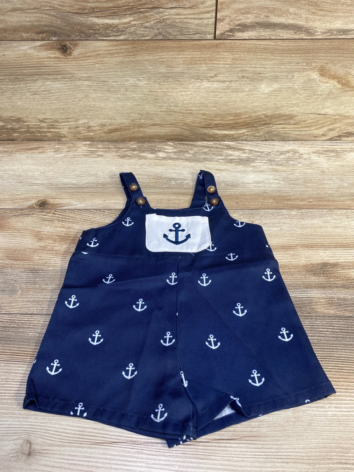 Front view of navy anchor print shortalls size 6 to 9 months showing anchor chest patch and adjustable button straps
