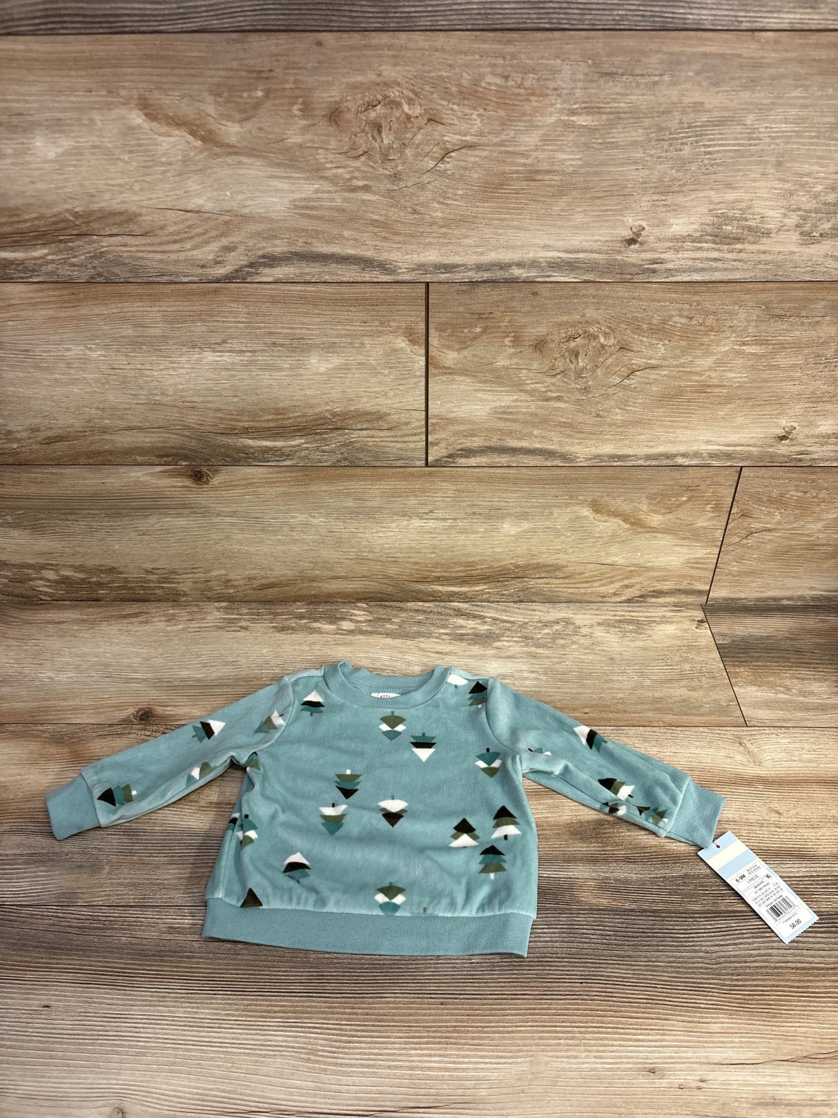 Kids blue long sleeve sweatshirt with geometric mountain print on wood background