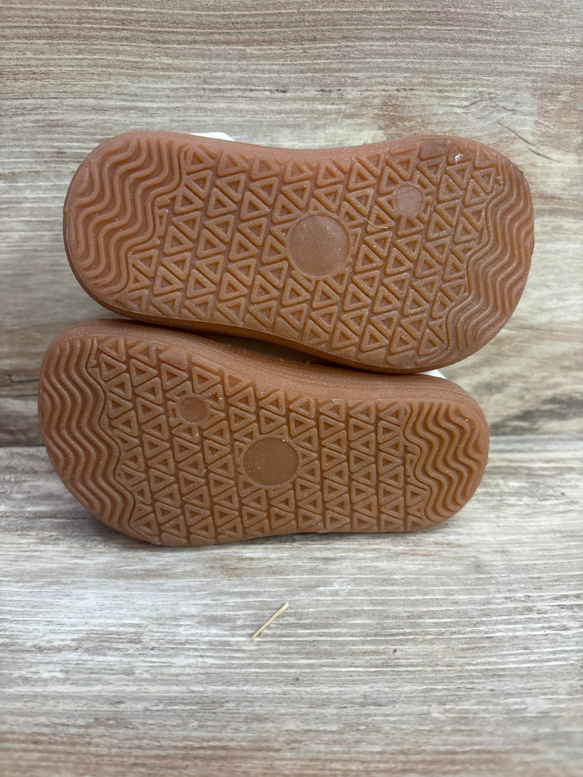 Bottom view of STQ KIDS wide toe box Mary Jane dress shoes showcasing textured soles on a wood-grain background