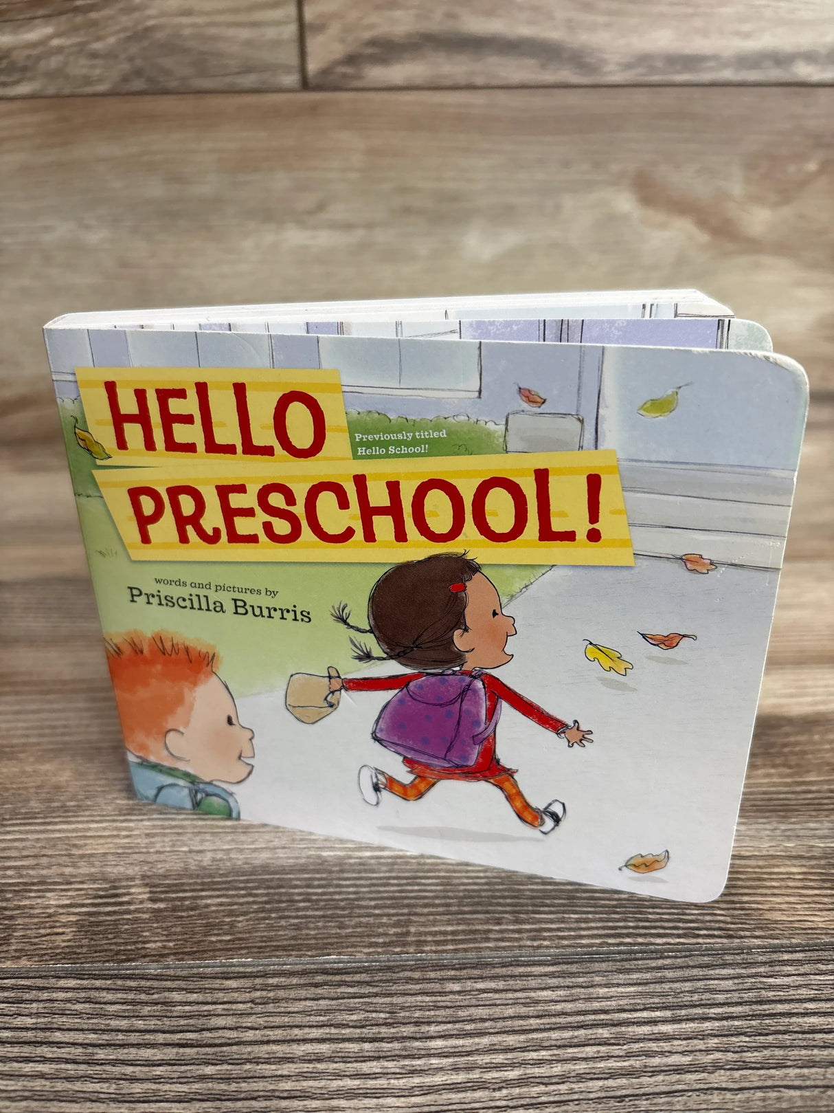 Board book titled Hello Preschool by Priscilla Burris with children illustration on wooden surface