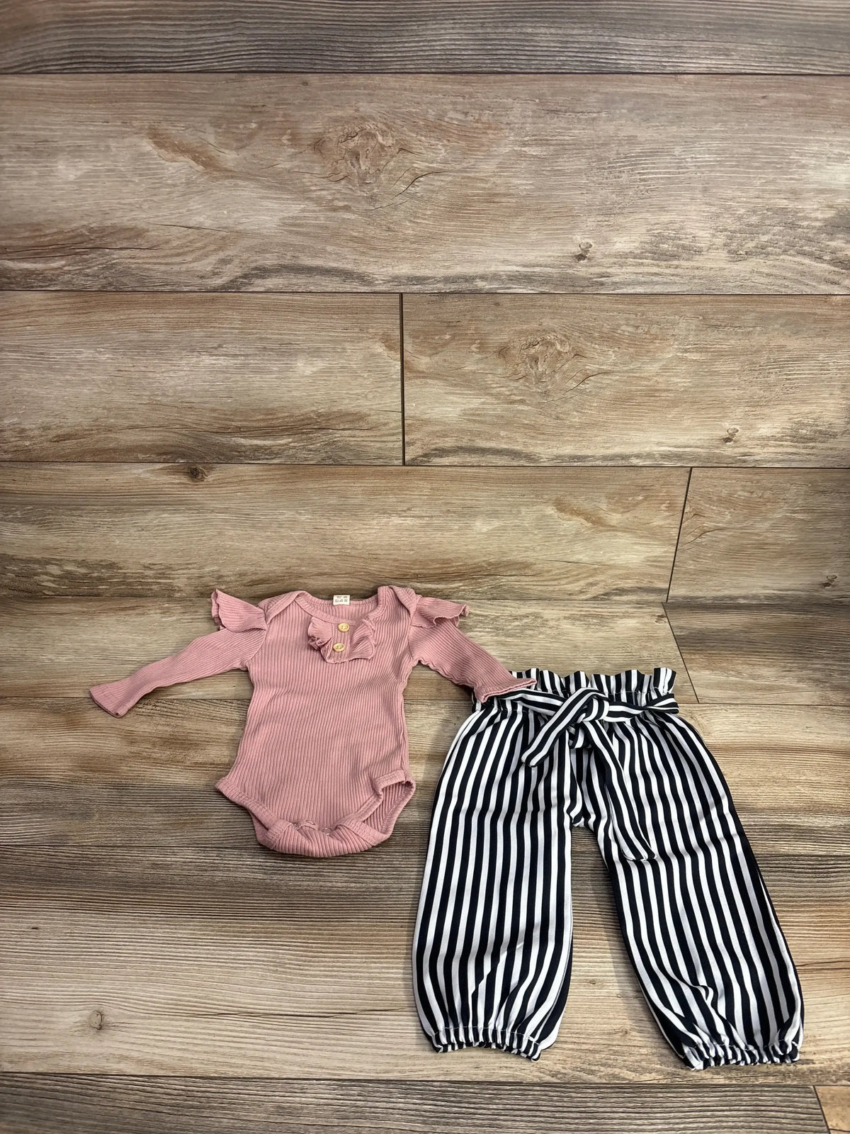 Pink ruffle long sleeve baby bodysuit with black and white striped toddler pants