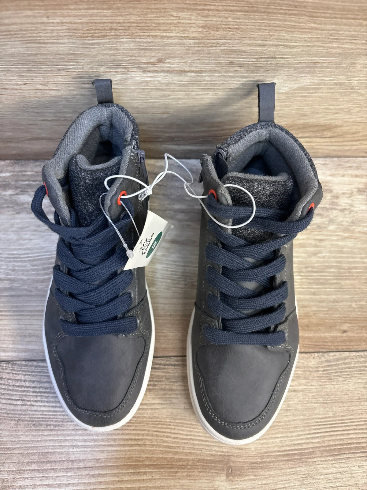 Gray high-top kids sneakers with navy laces on wood floor, resale store product photo