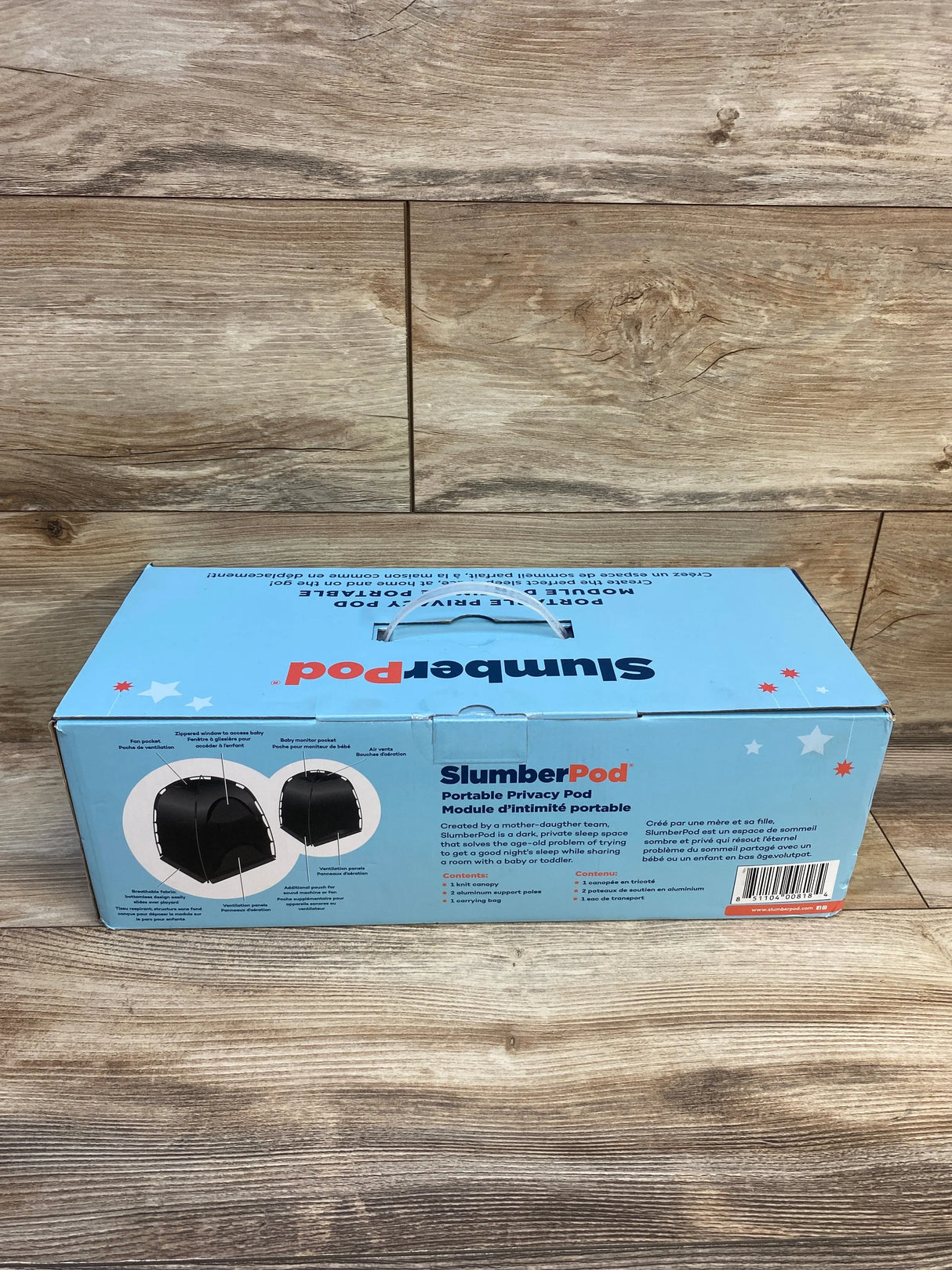 SlumberPod portable privacy pod for babies and toddlers, boxed on wooden floor