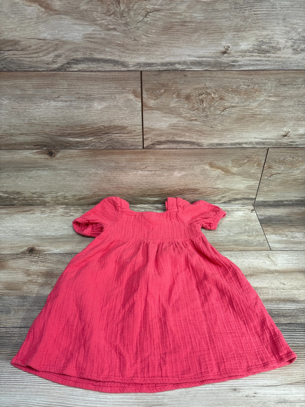 Hot pink Cat & Jack puff sleeve dress for toddlers on a wooden background